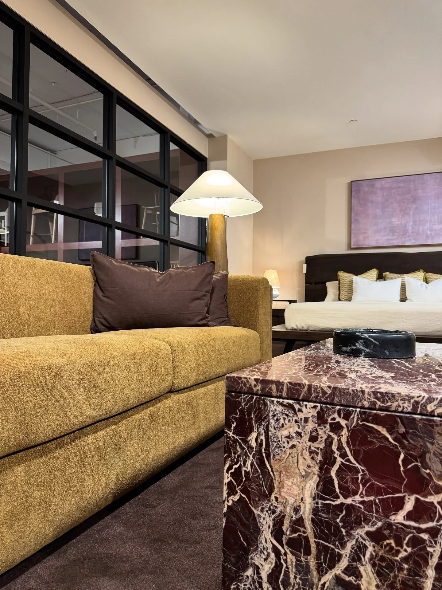 Mustard sofa beside a deep red veined stone coffee table