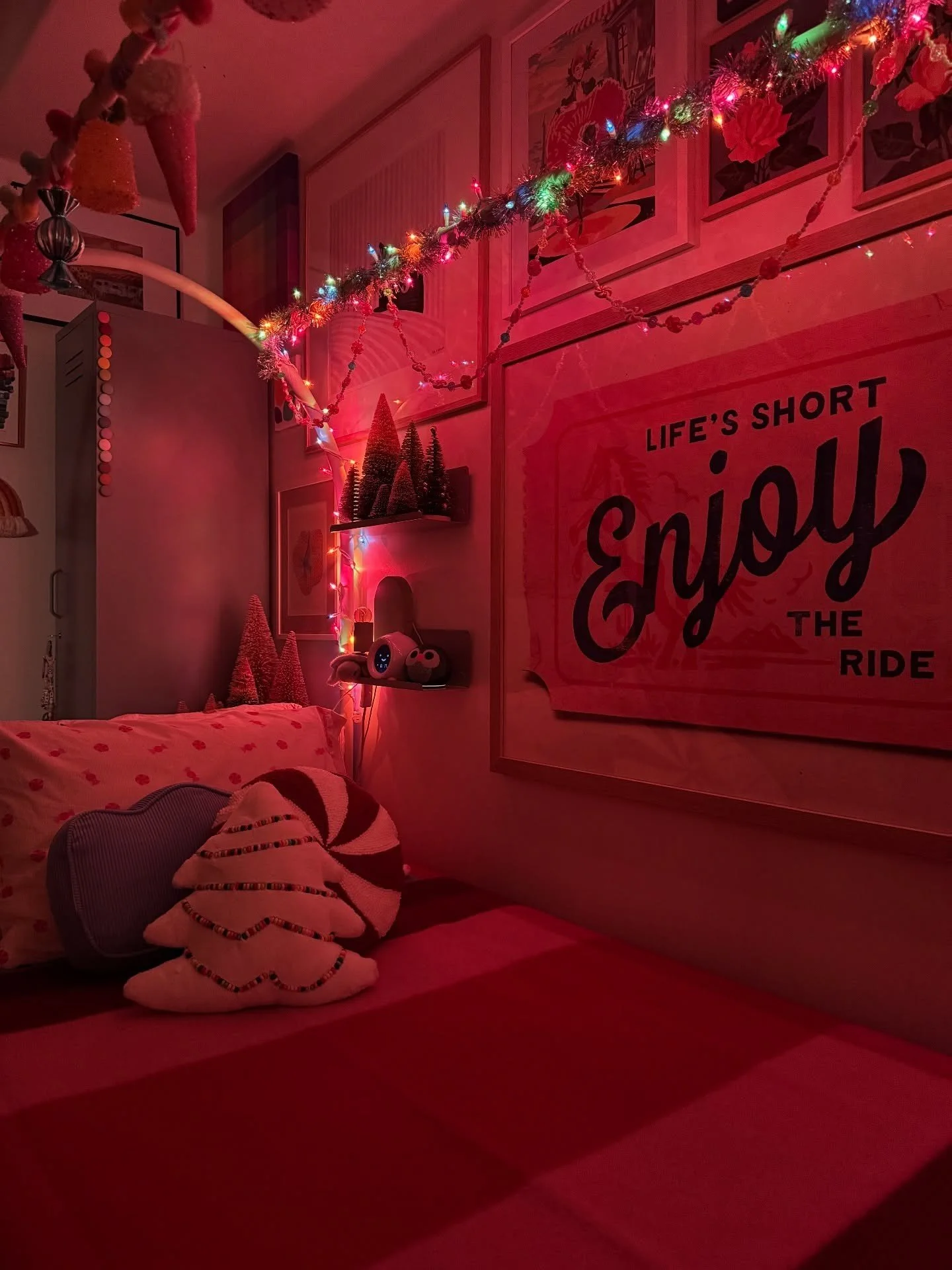 Bedroom art wall and garland illuminated by red lights