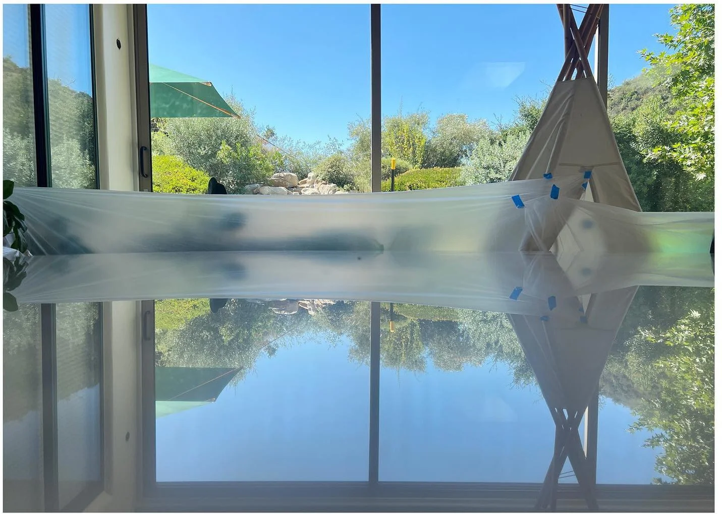 Polished marble tabletop reflecting windows and a bright garden view