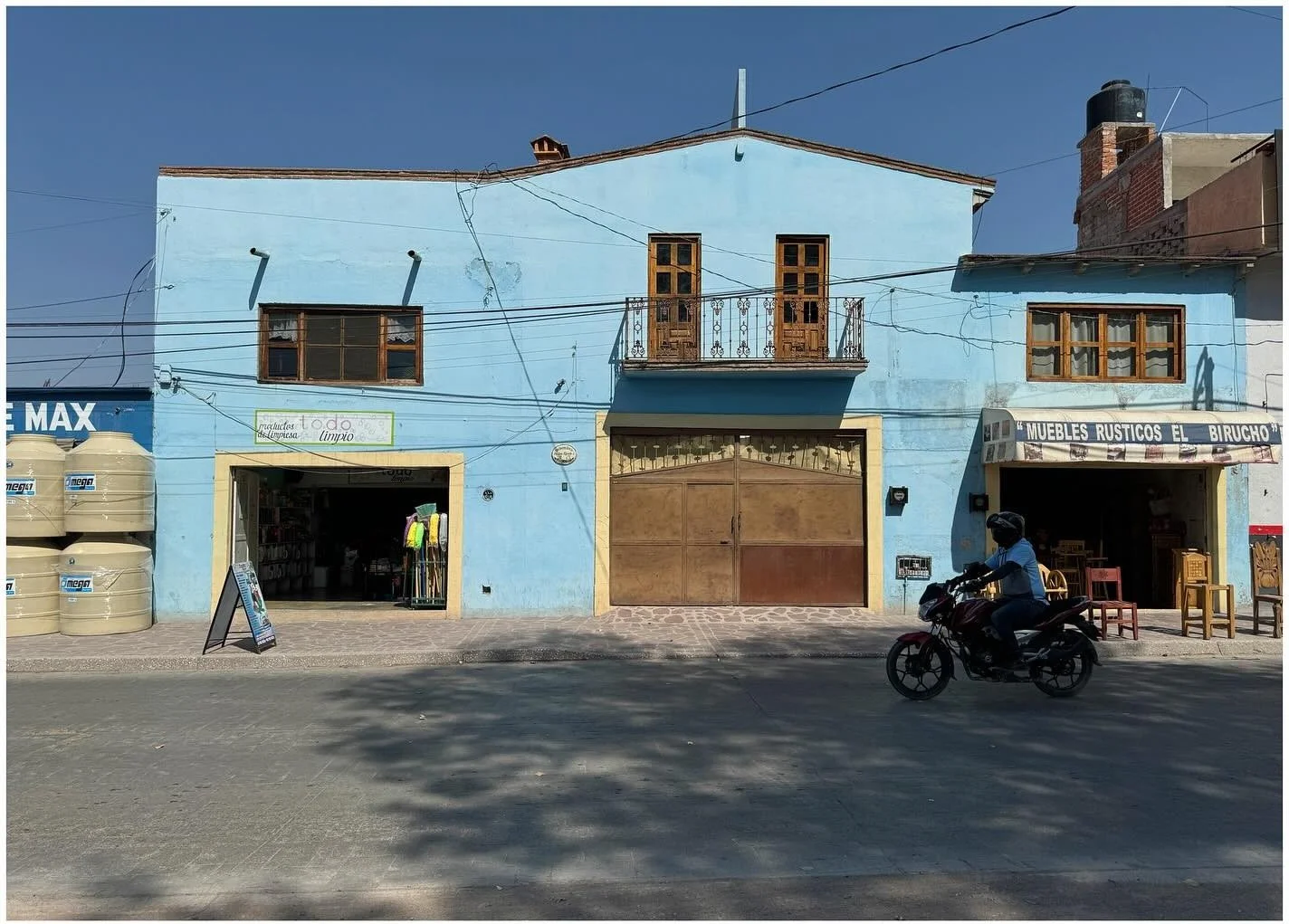 Pale blue historic storefront beneath utility wires