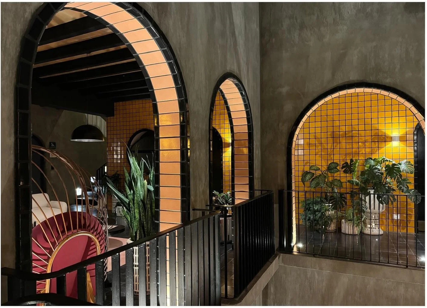 Curving arched opening and metal balustrade above a courtyard