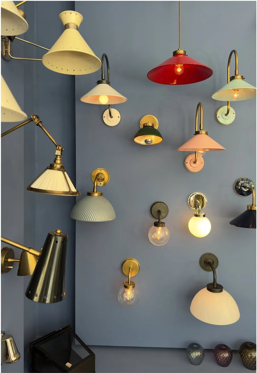 Collection of colorful wall sconces displayed on a blue wall