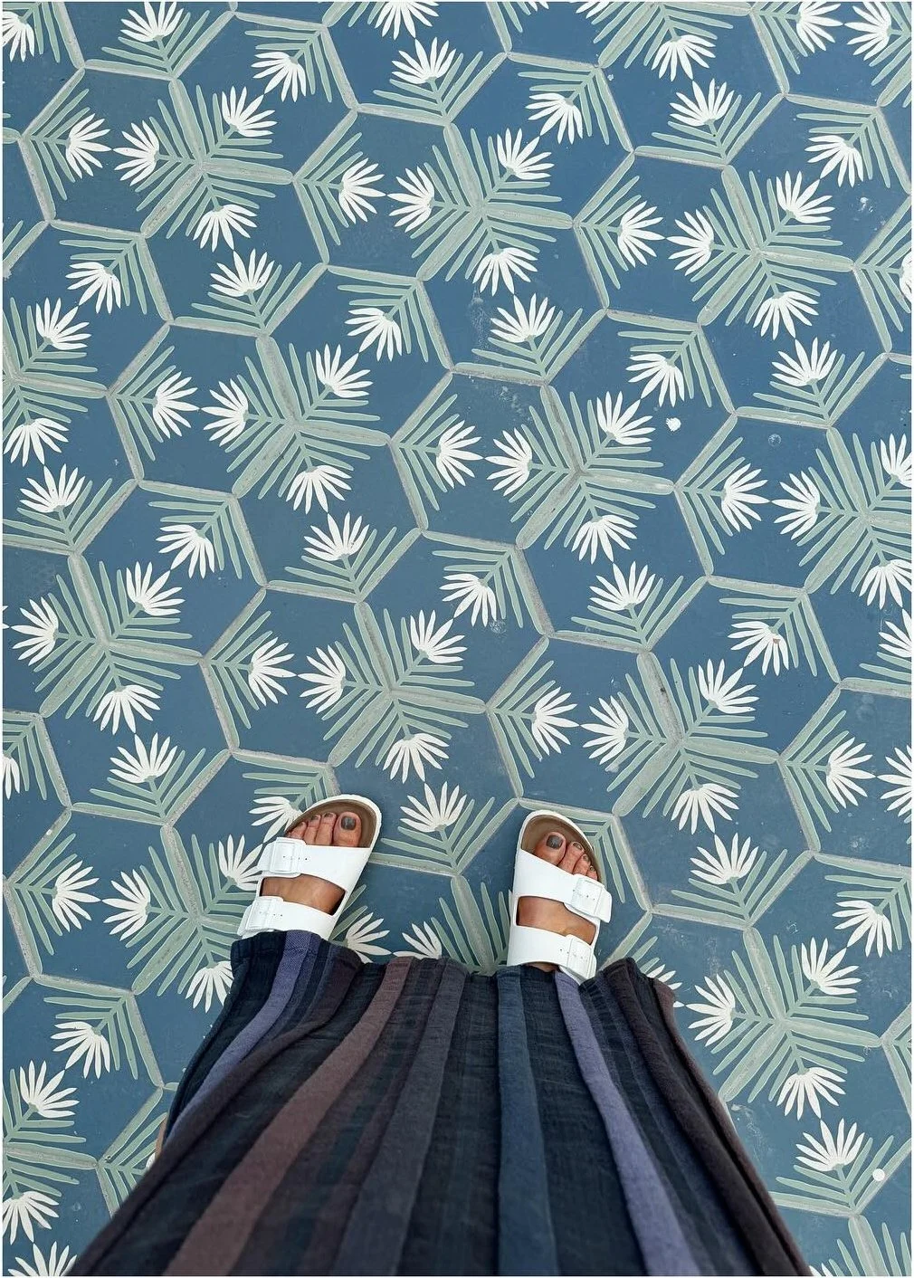 Blue patterned tile floor with repeating pale botanical motifs
