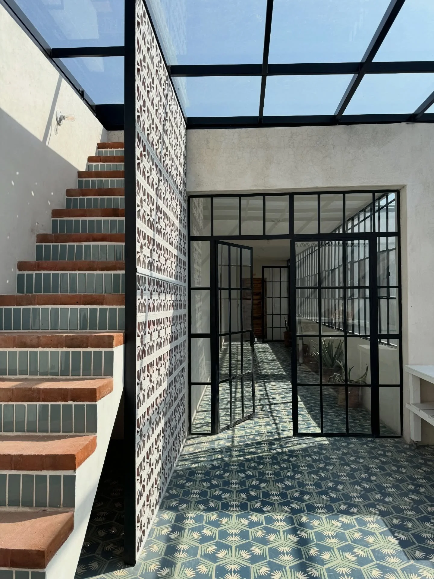 Tiled stairwell with black metal railings and patterned floor