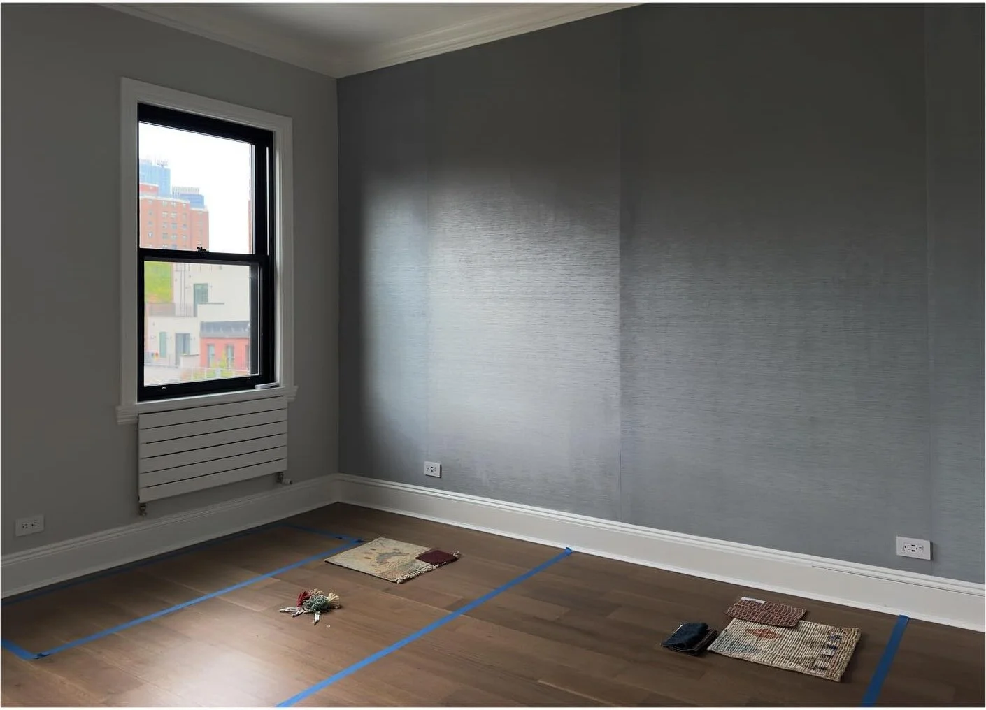 Empty room with pale gray walls original trim and wood floor