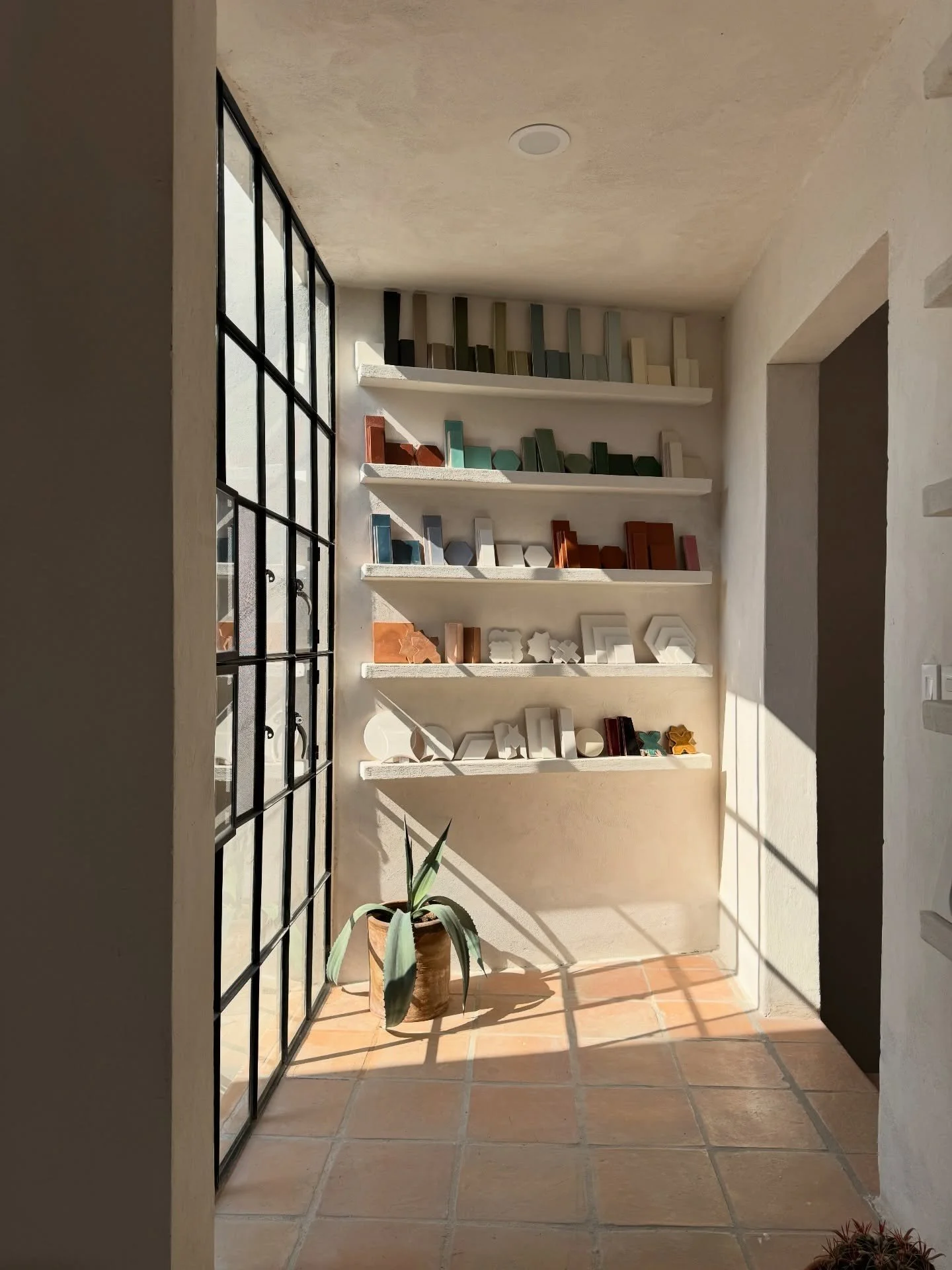 Sunlit showroom shelves with ceramics and sample boards