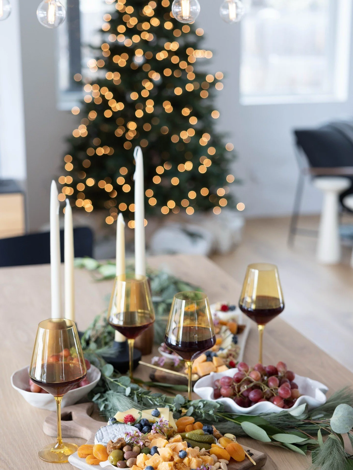Holiday table setting with food wine and glowing tree lights