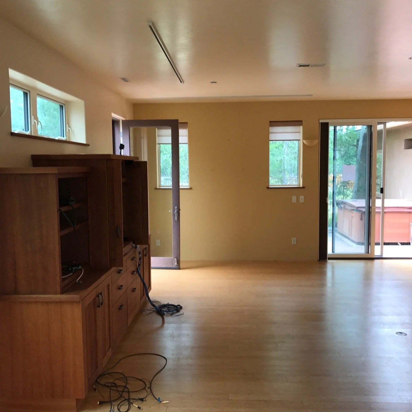 Empty original living space with oak floor and wood cabinetry