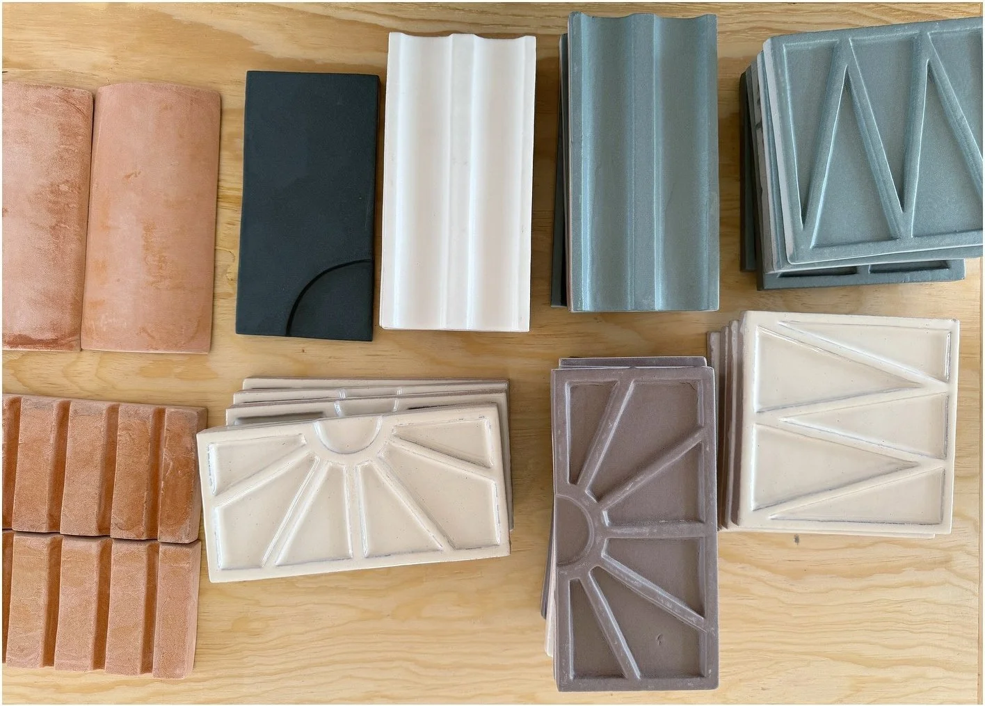 Collection of raised tile samples in blue gray white and terracotta
