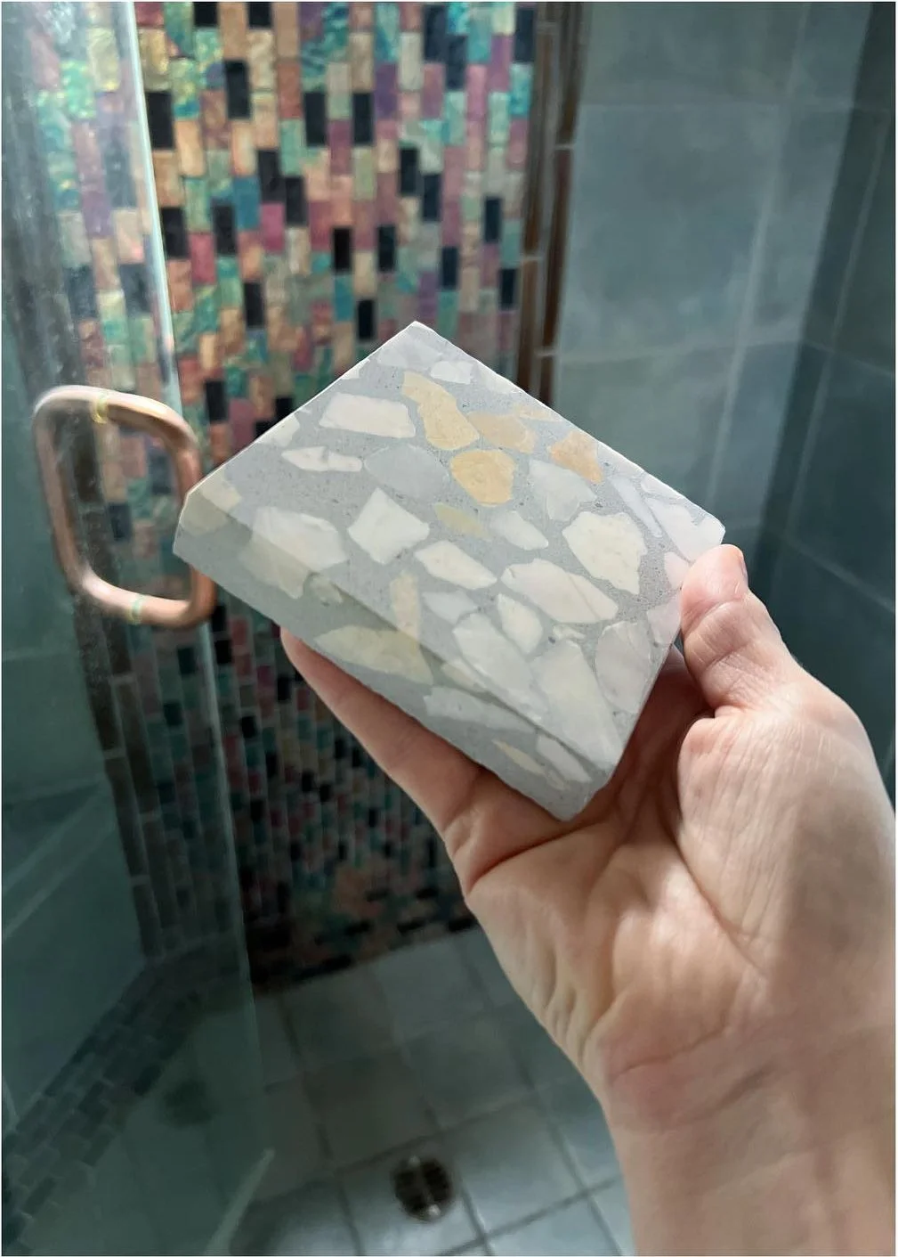 Terrazzo sample compared with the existing mosaic shower wall
