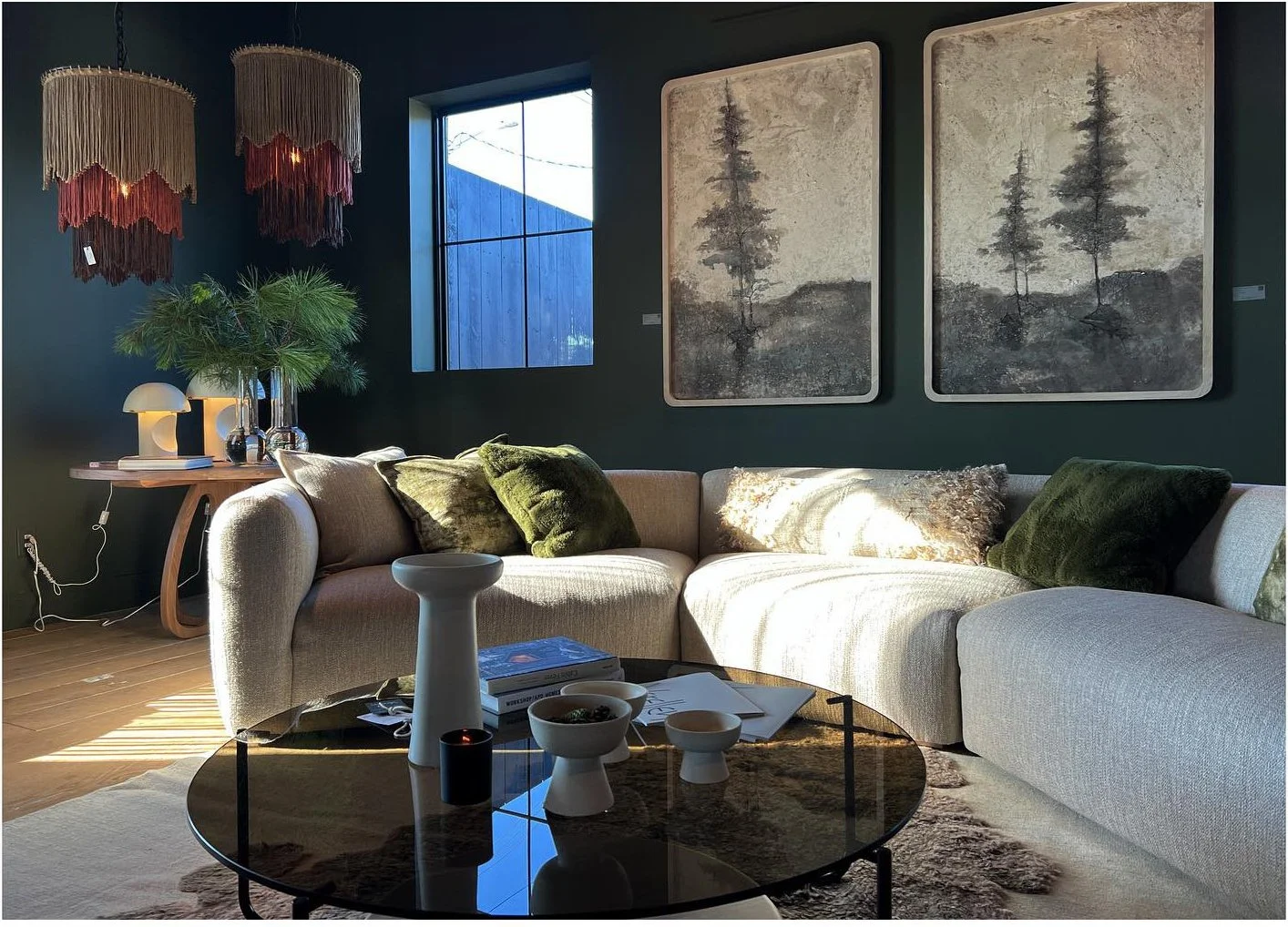 Pale sofa and black coffee table beneath framed botanical artwork