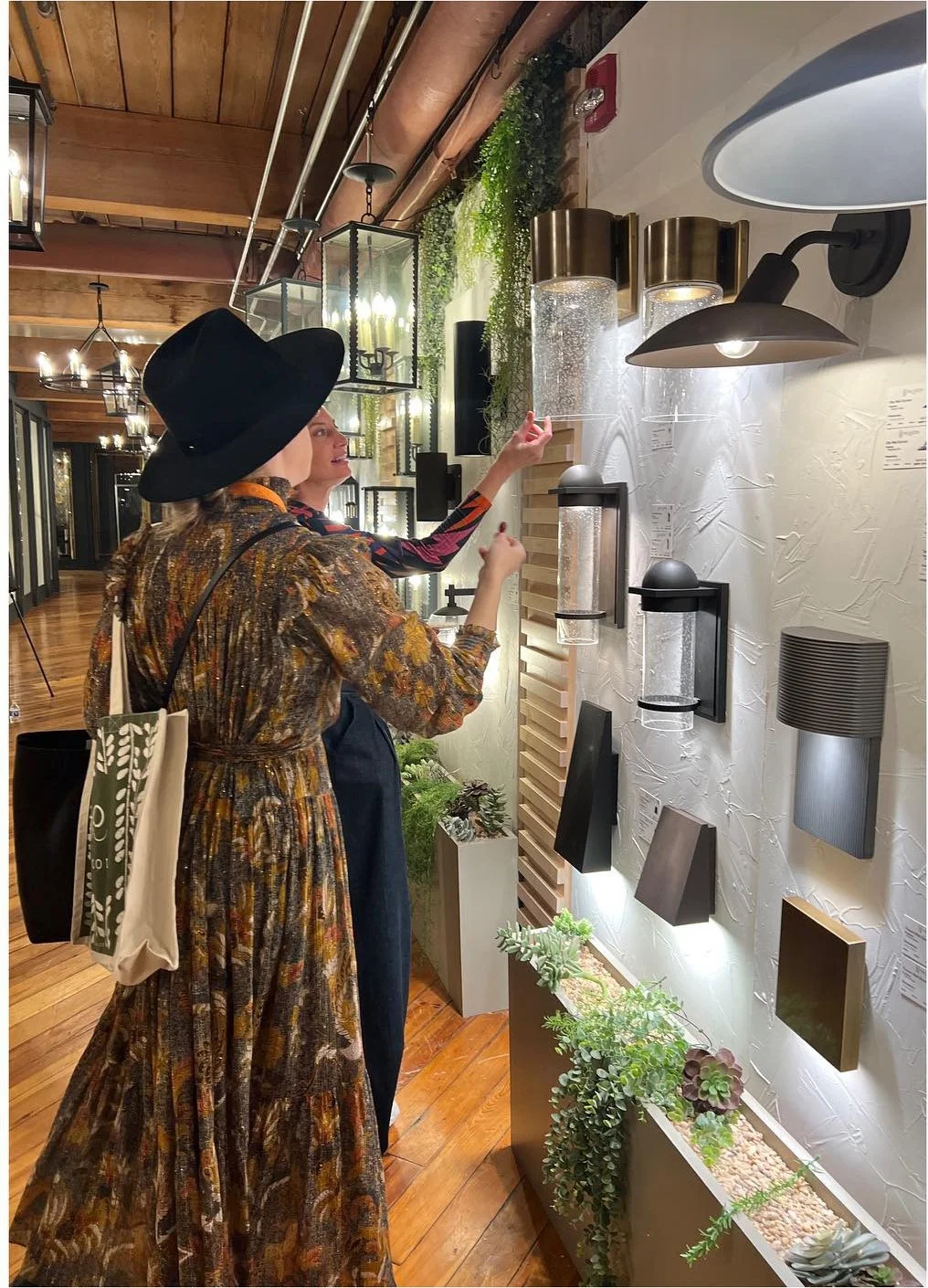 Designer comparing cylindrical and curved wall sconces