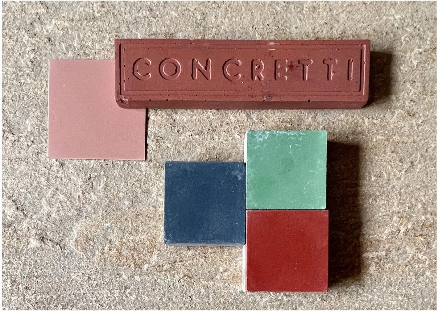 Red concrete sample with blush blue green and burgundy tile chips
