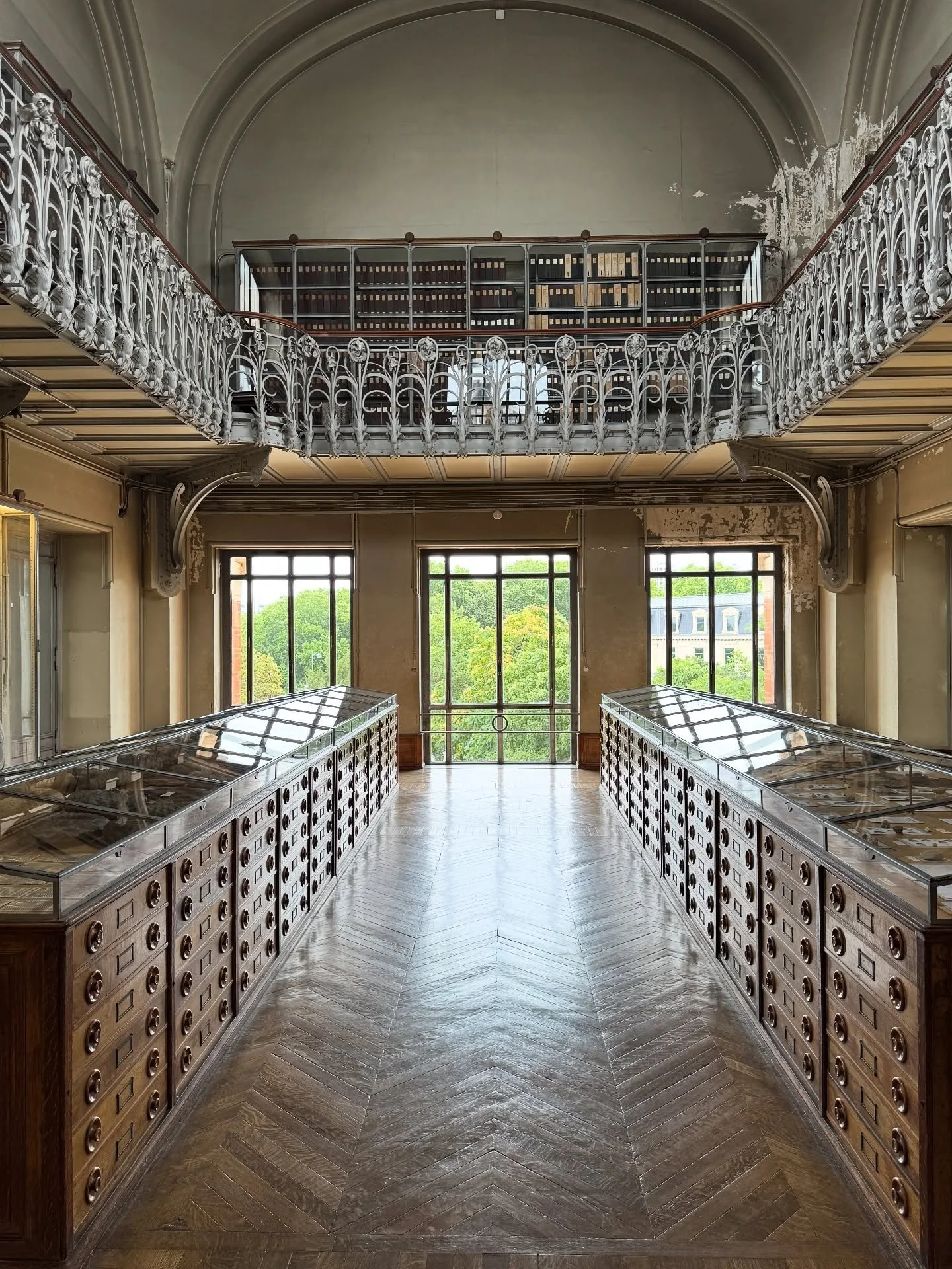 Historic museum gallery with timber cabinets and an upper balcony