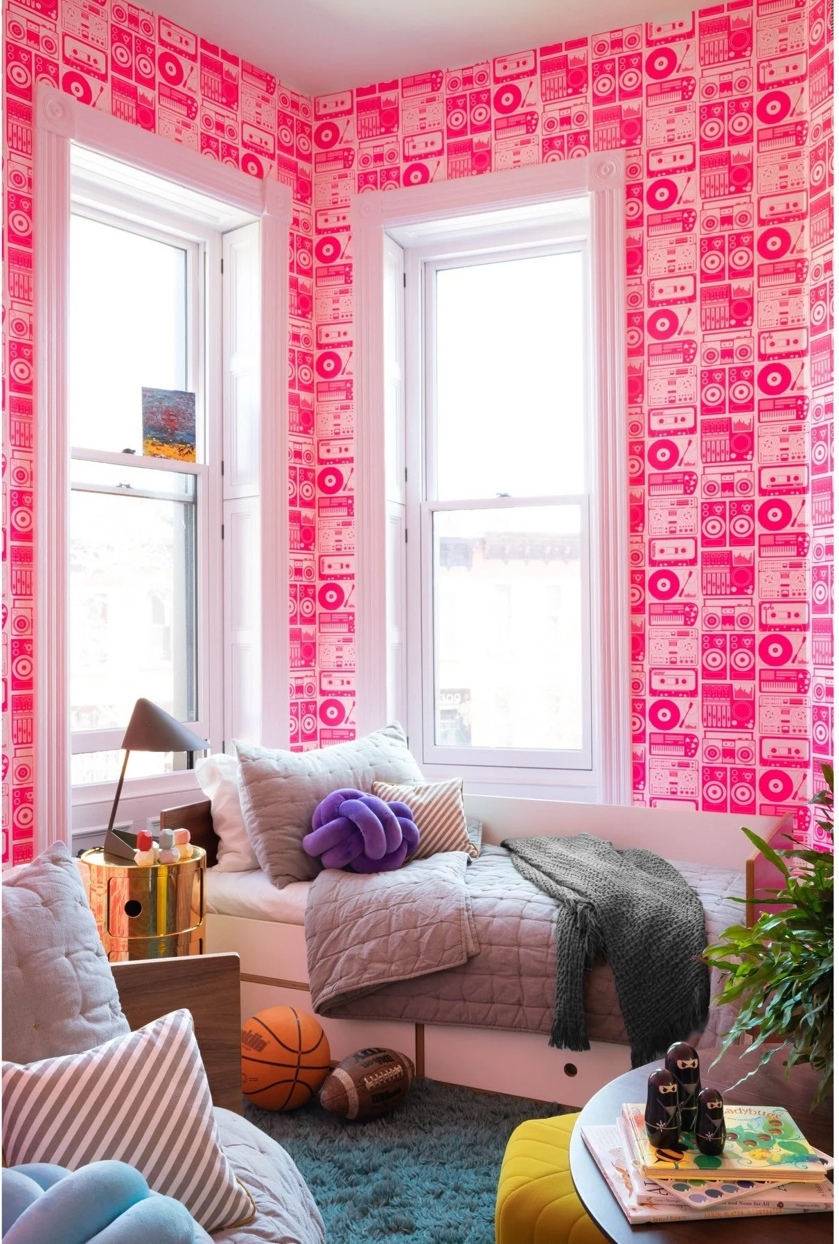 Pink patterned sitting room with a pale upholstered chair