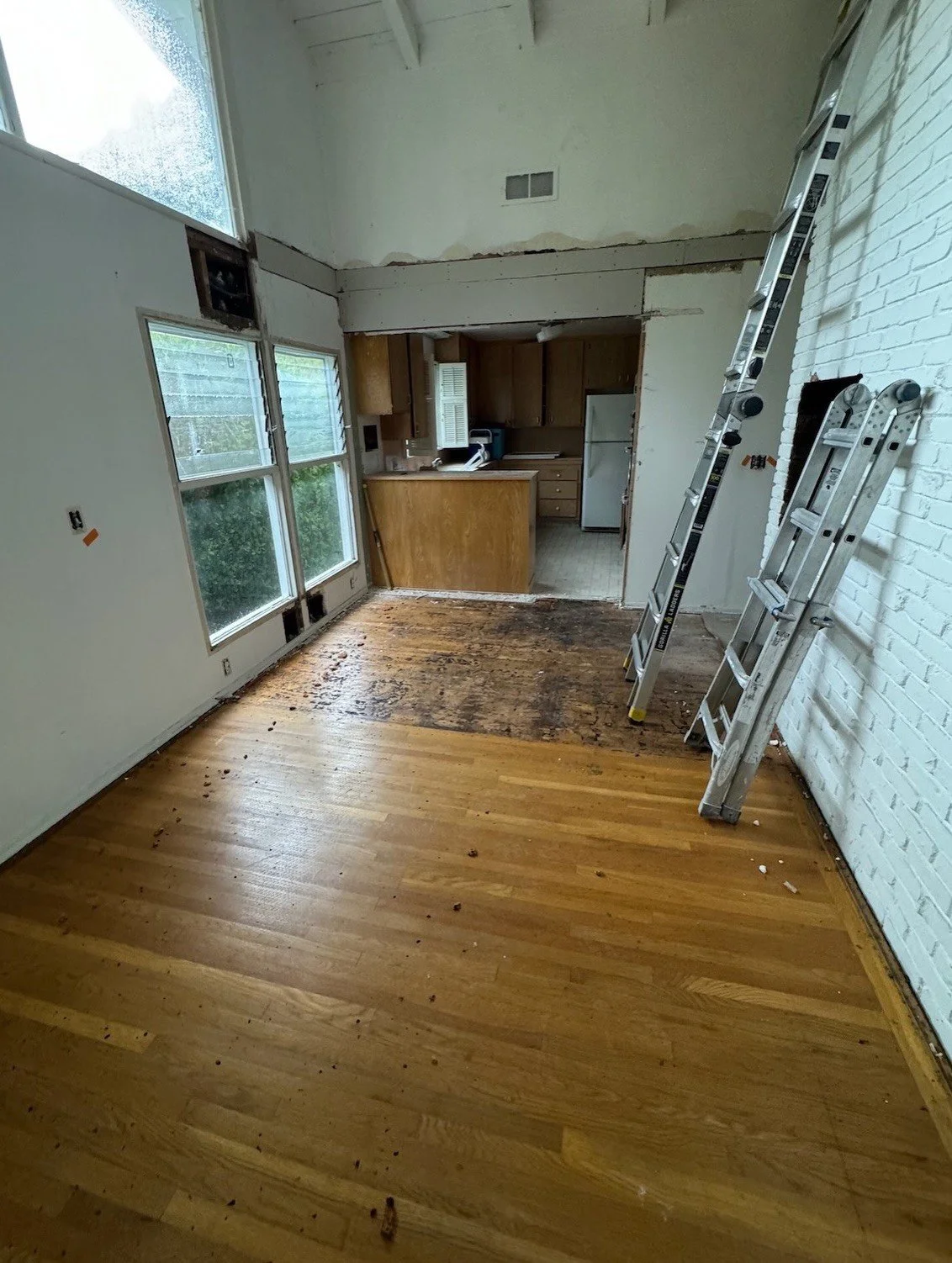Renovation in progress with stripped walls and exposed wood floor