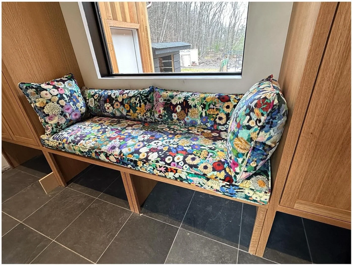 Floral velvet bench cushion on a built-in wood window seat
