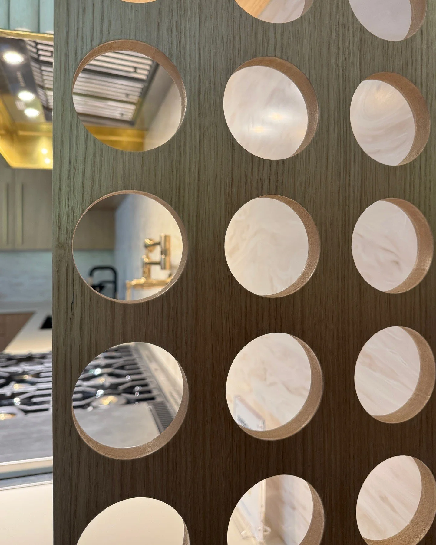 Circular cutouts and mirrors in a decorative wood screen