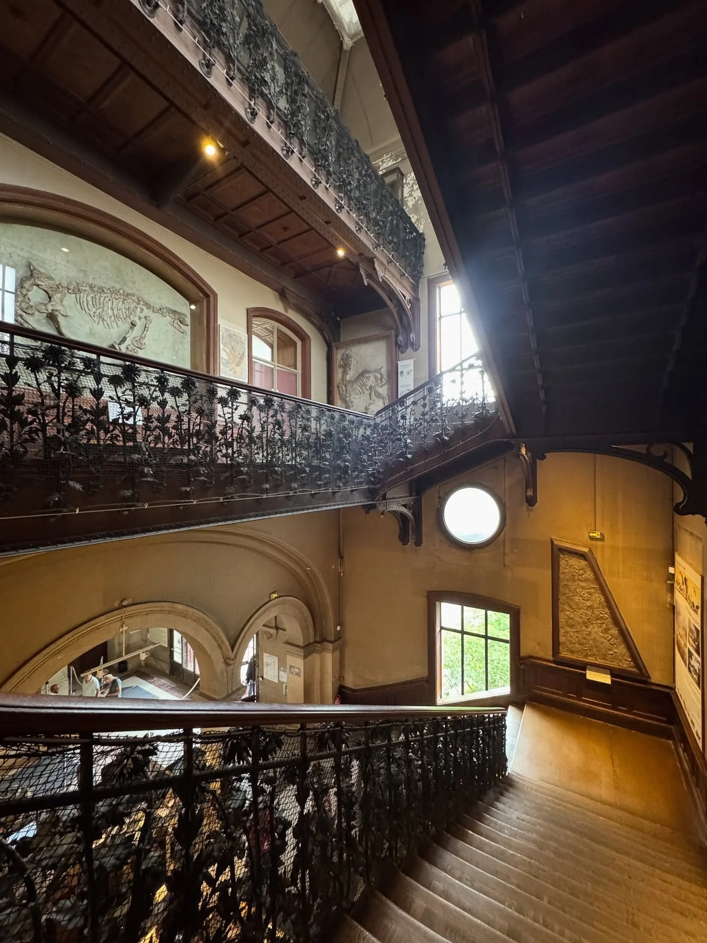Double-height museum interior with carved balconies and tall windows