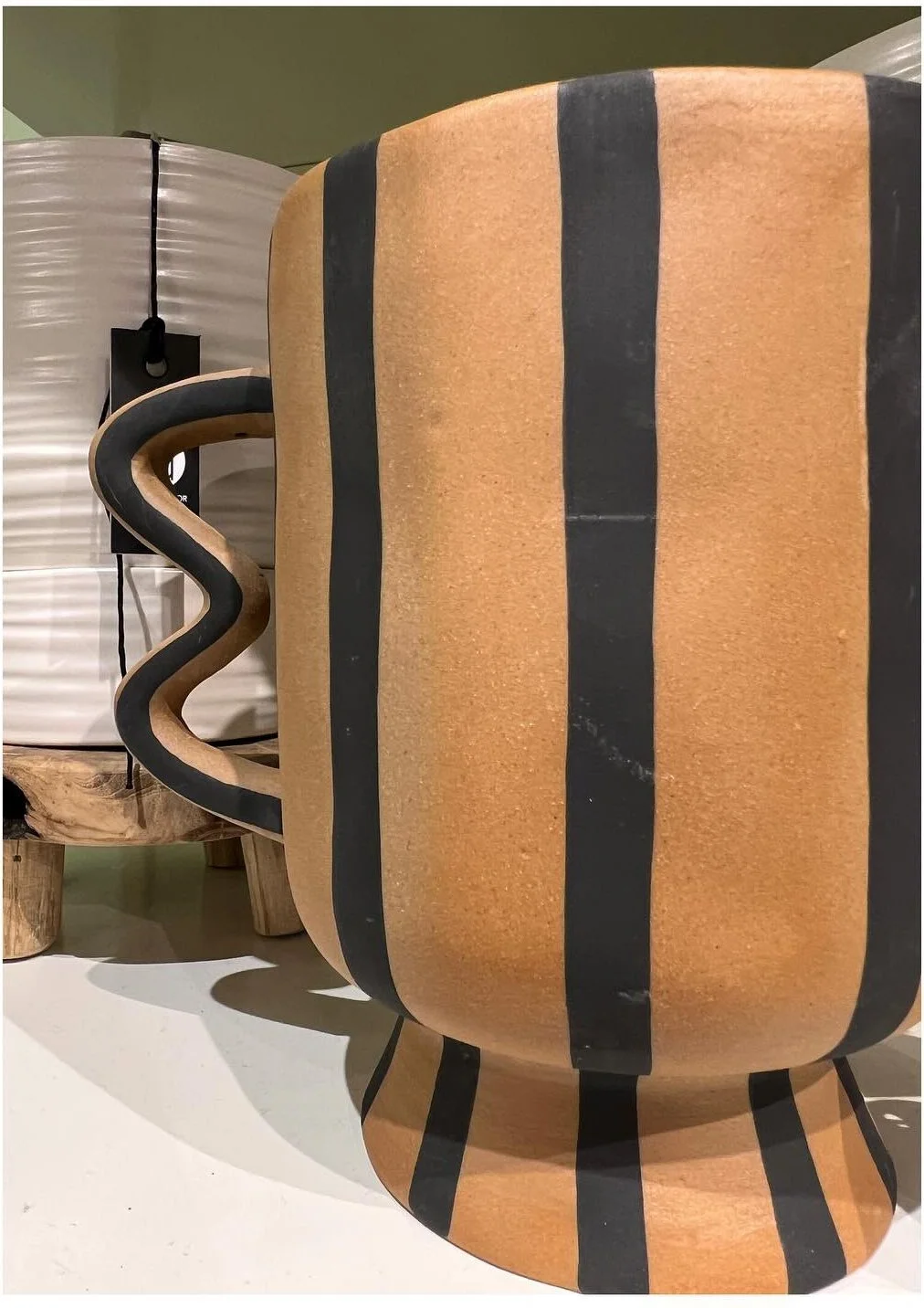 Tall terracotta planter with wide black vertical stripes