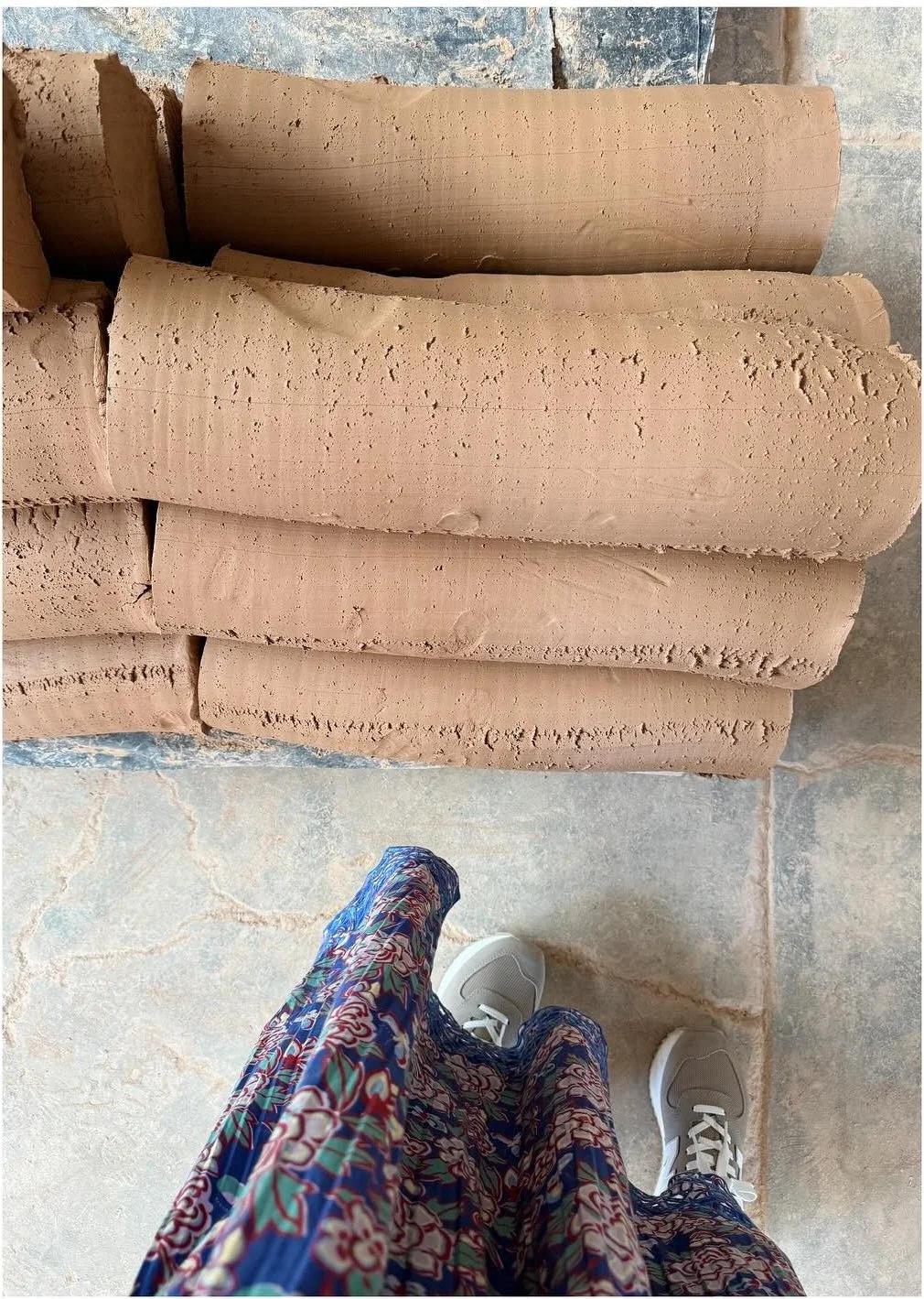 Large raw clay rolls stored inside a tile workshop
