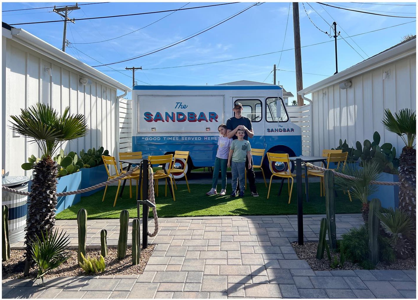 Coastal shop frontage with planting and a painted outdoor mural