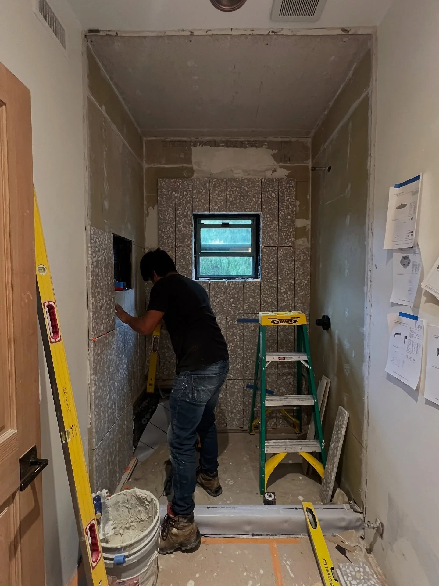 Contractor working in a bathroom during tile installation