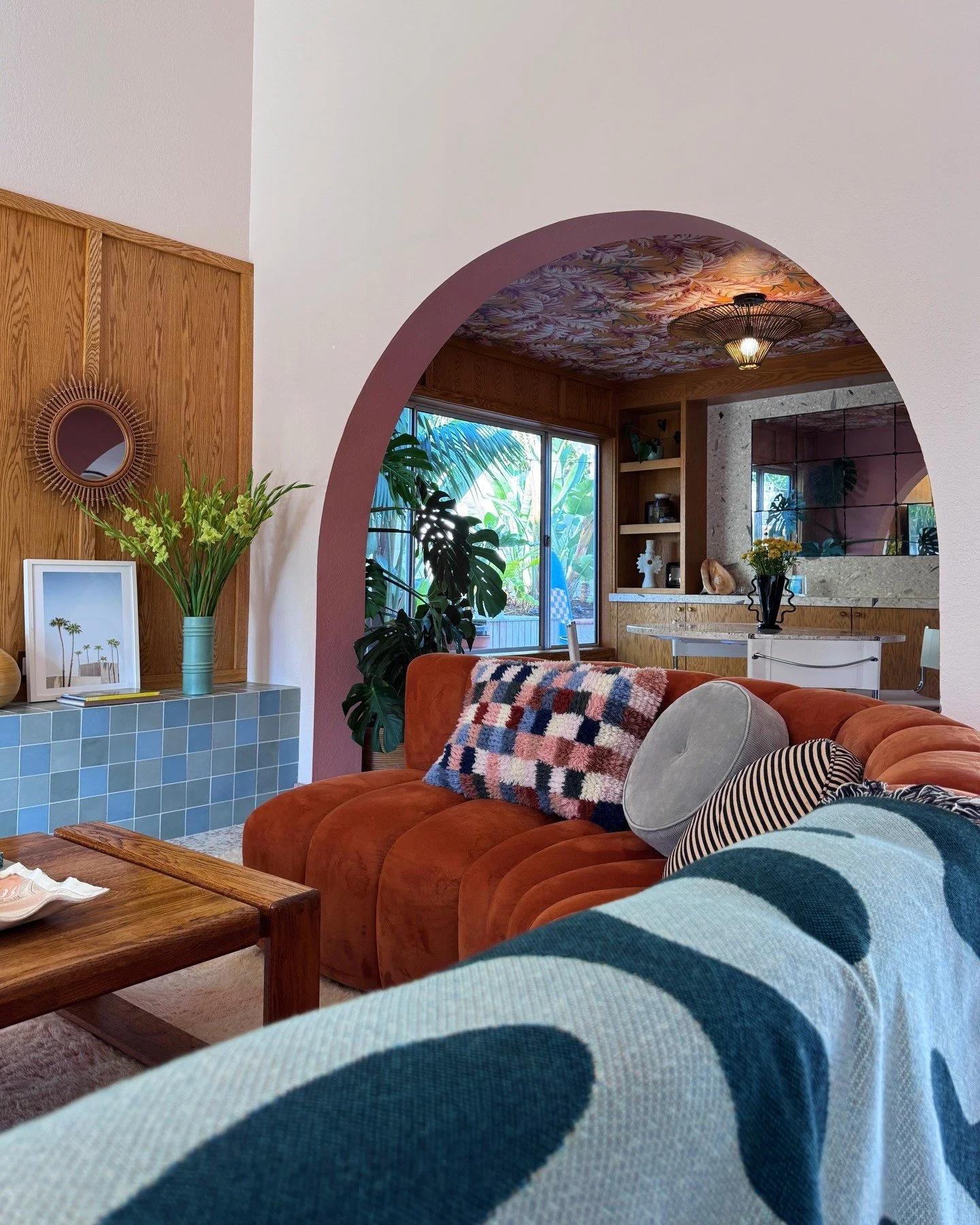 Arched doorway between layered blue and orange living spaces