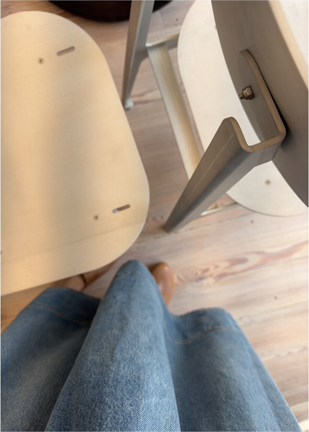 Close-up of a pale curved chair and jointed metal structure