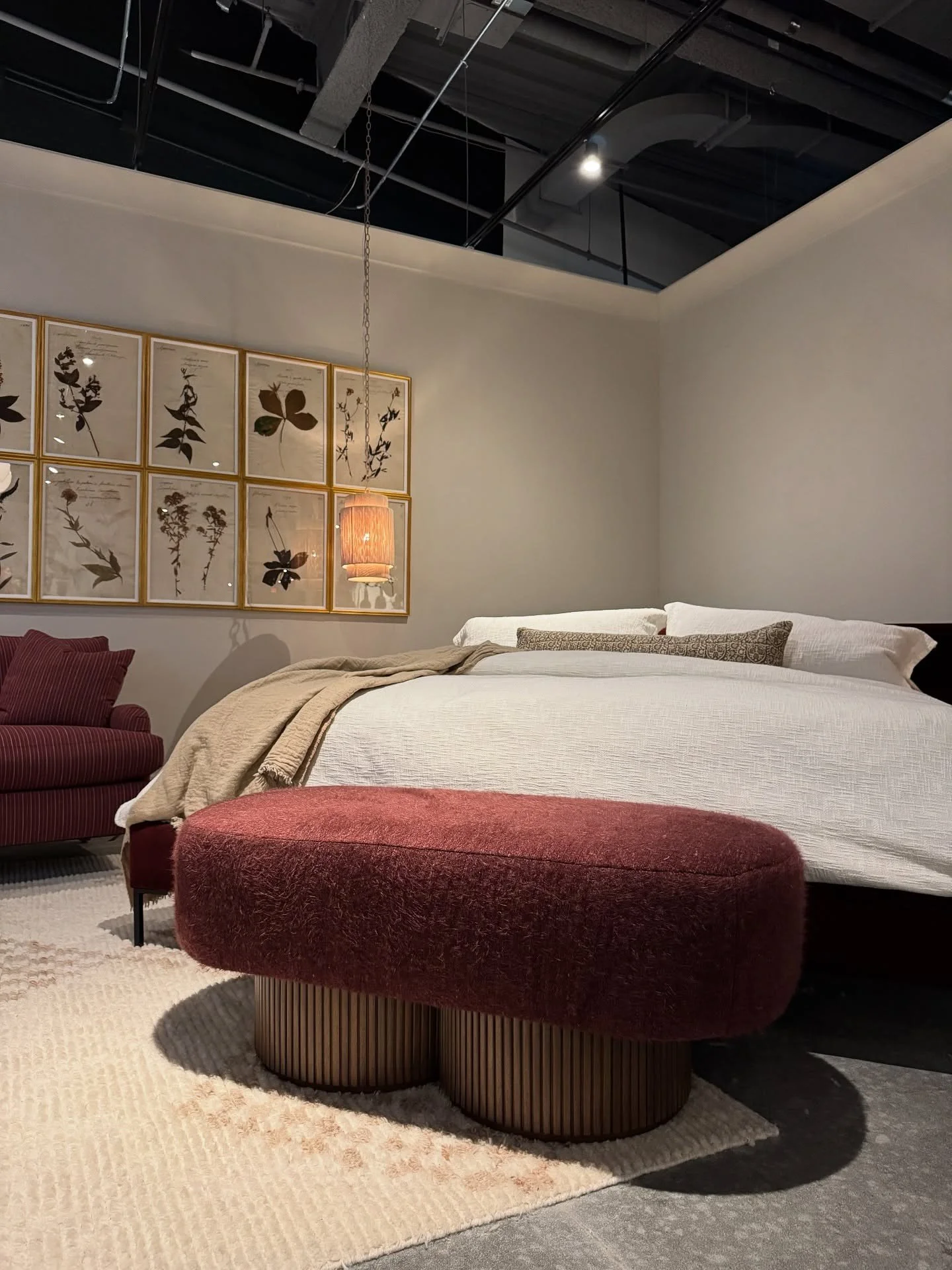 Bedroom display with a low red upholstered bench