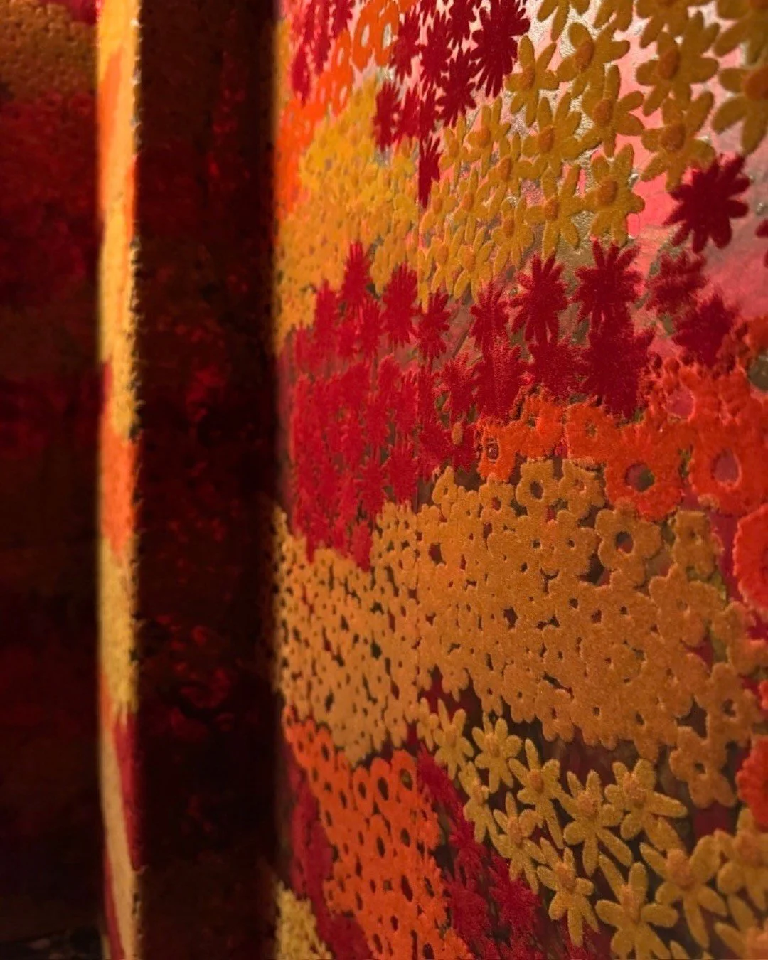 Close-up of a richly patterned red and orange textile