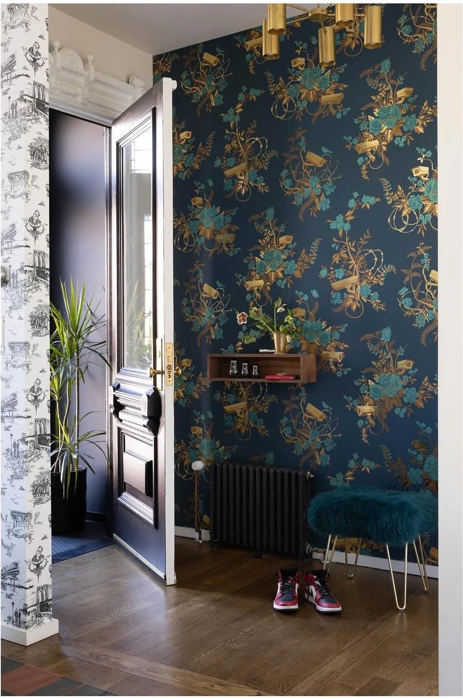 Dark botanical wallpaper beside a black-trimmed kitchen doorway