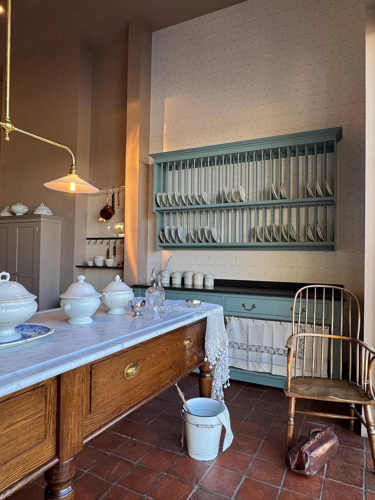 Wood kitchen counter beneath a green plate rack