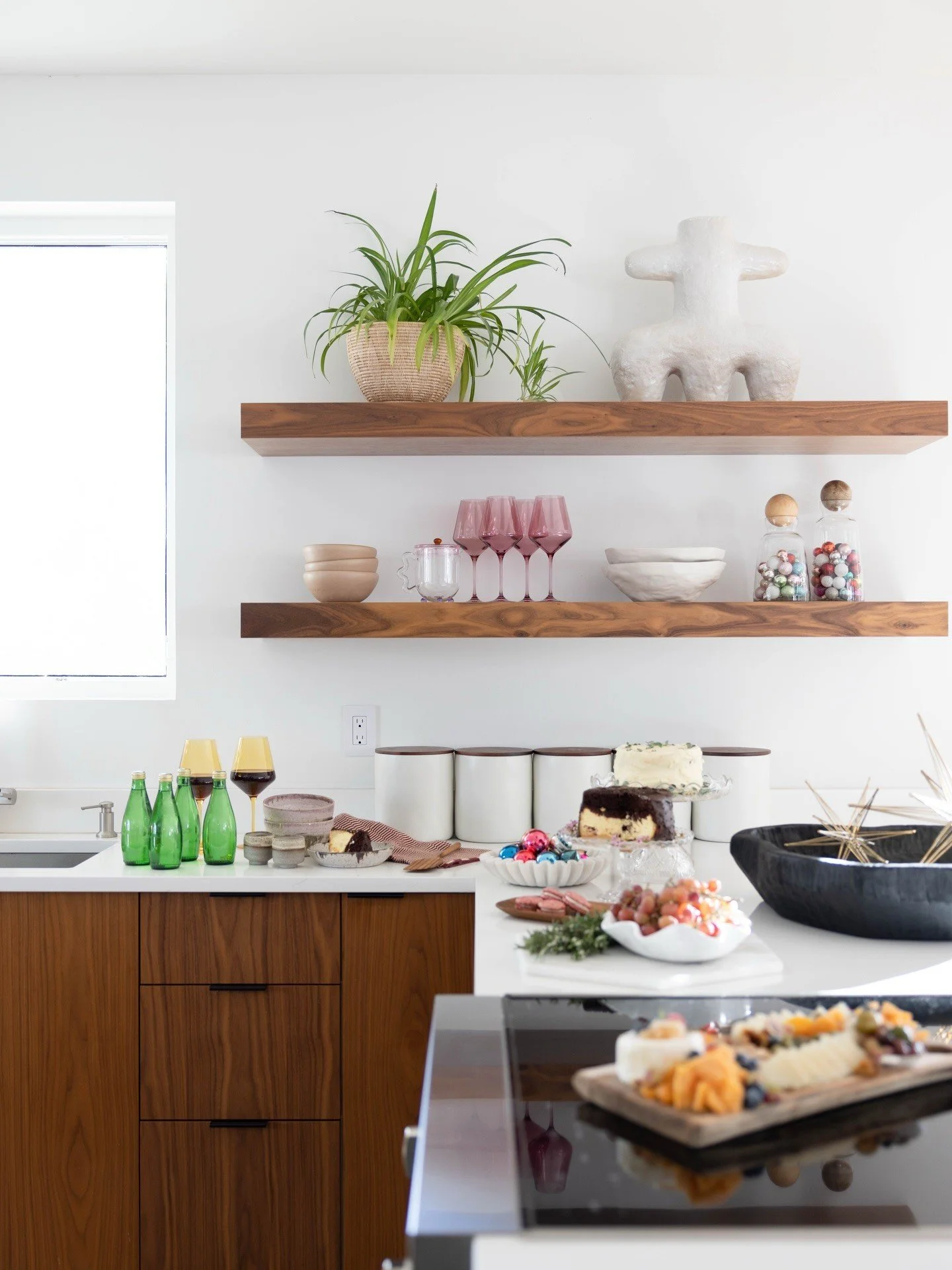 White kitchen with wood cabinets and colorful glassware