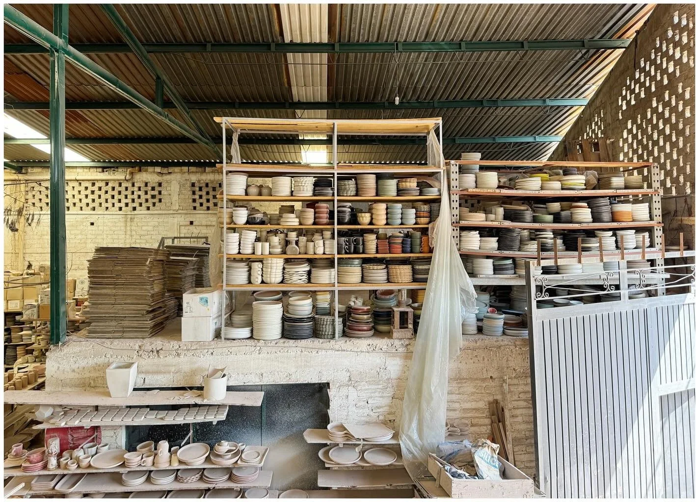 Pottery workshop with shelves of vessels and production materials