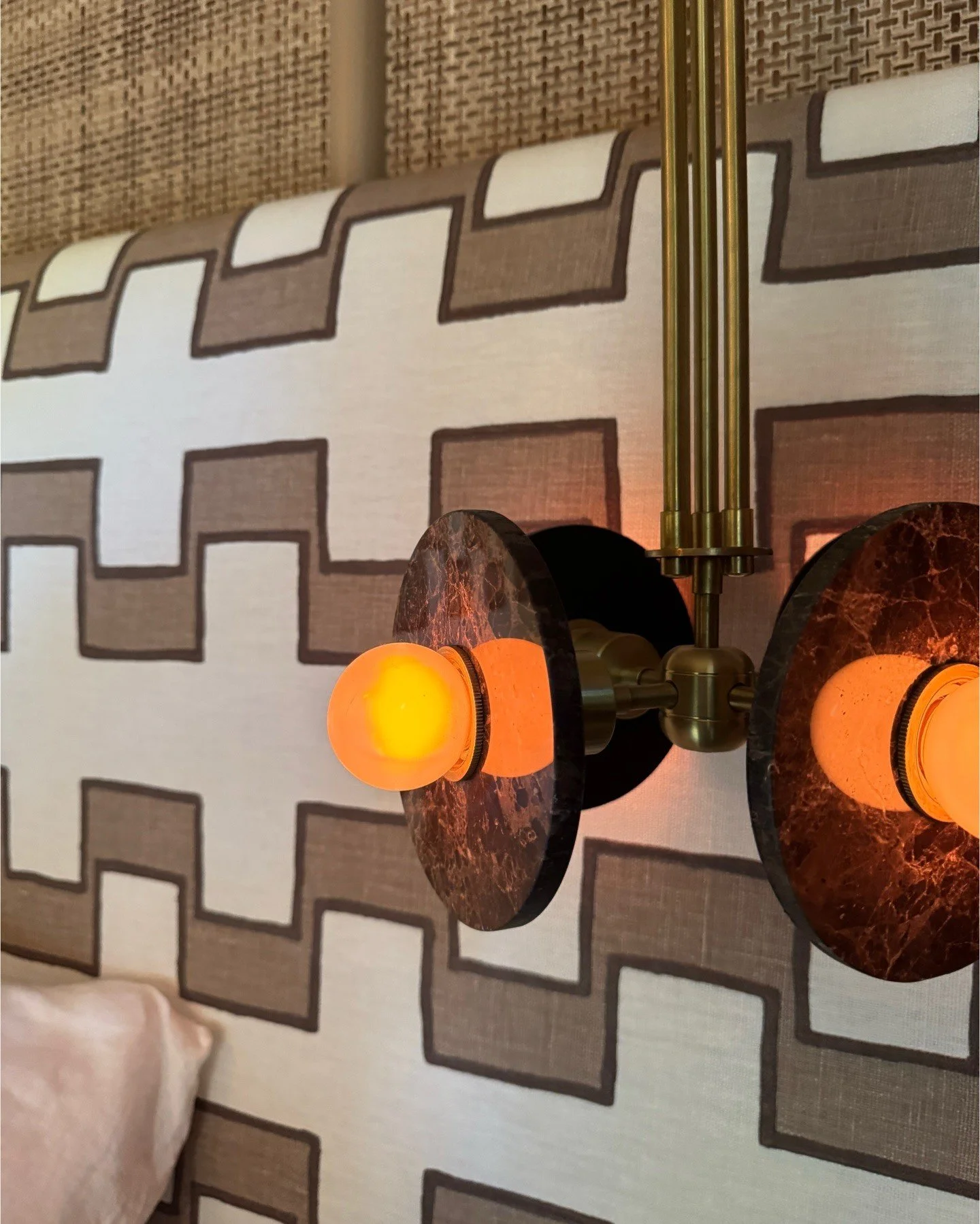 Amber wall sconces mounted on geometric wallpaper