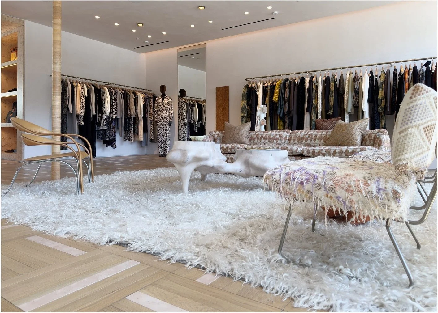 Bright fashion showroom with pale sculptural furniture and soft rugs