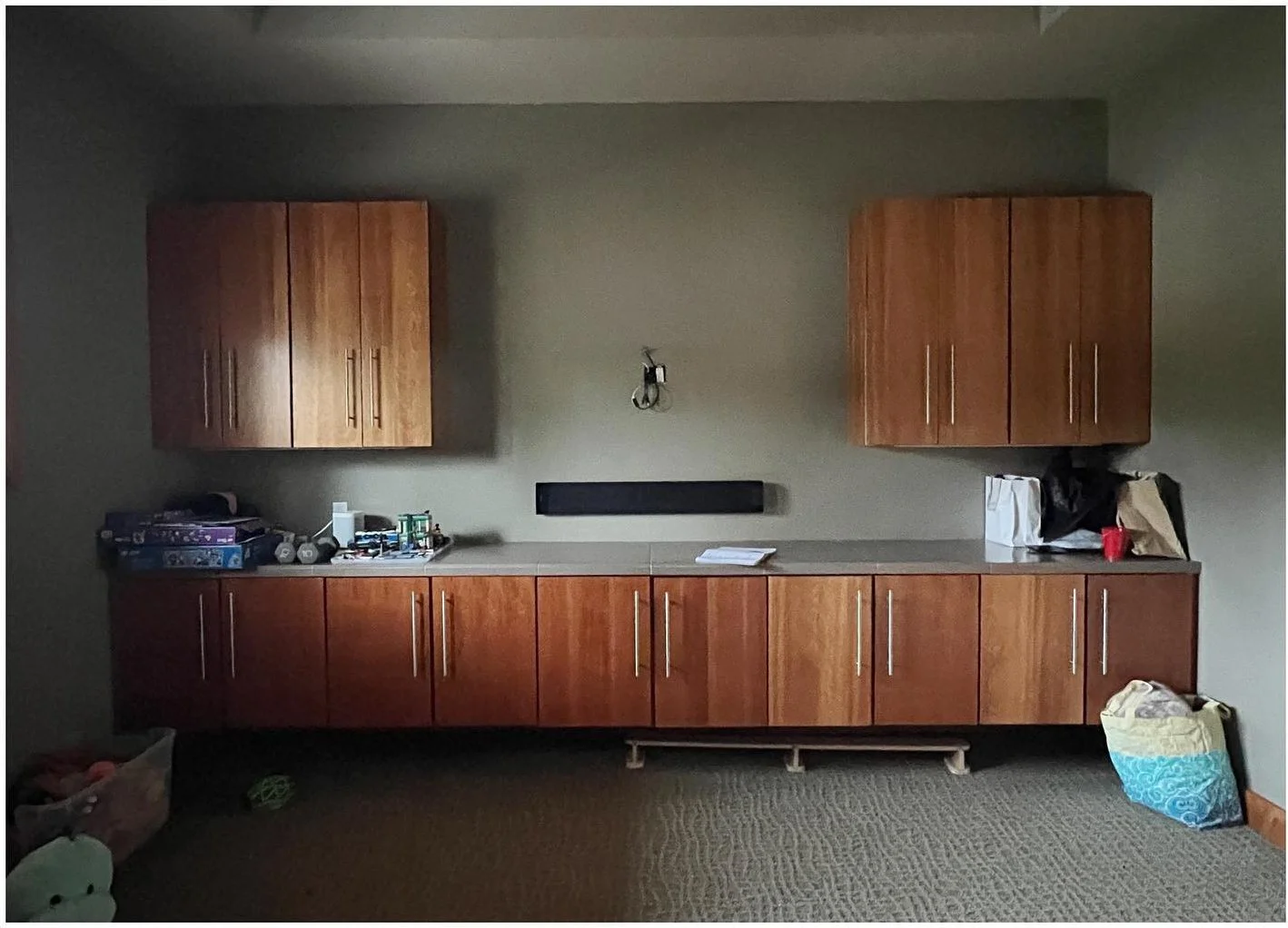 Original dark media room with wood cabinets and a low window