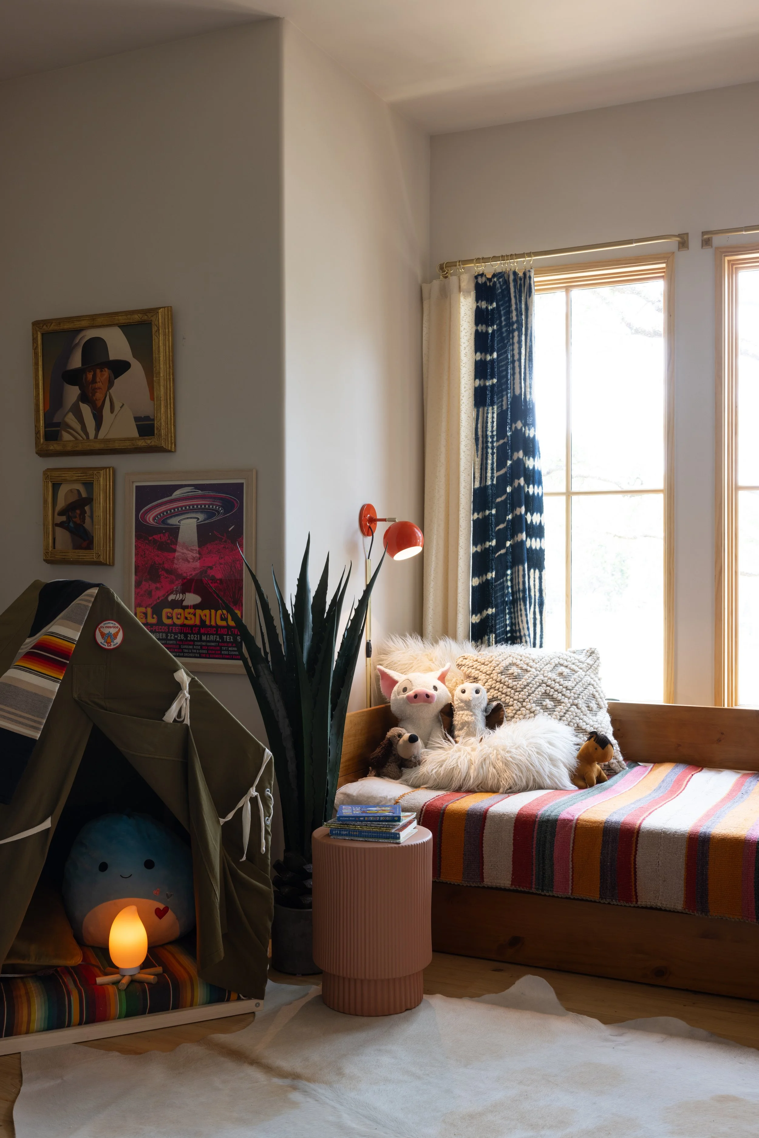 Cozy window seat with striped cushions and a small play tent.