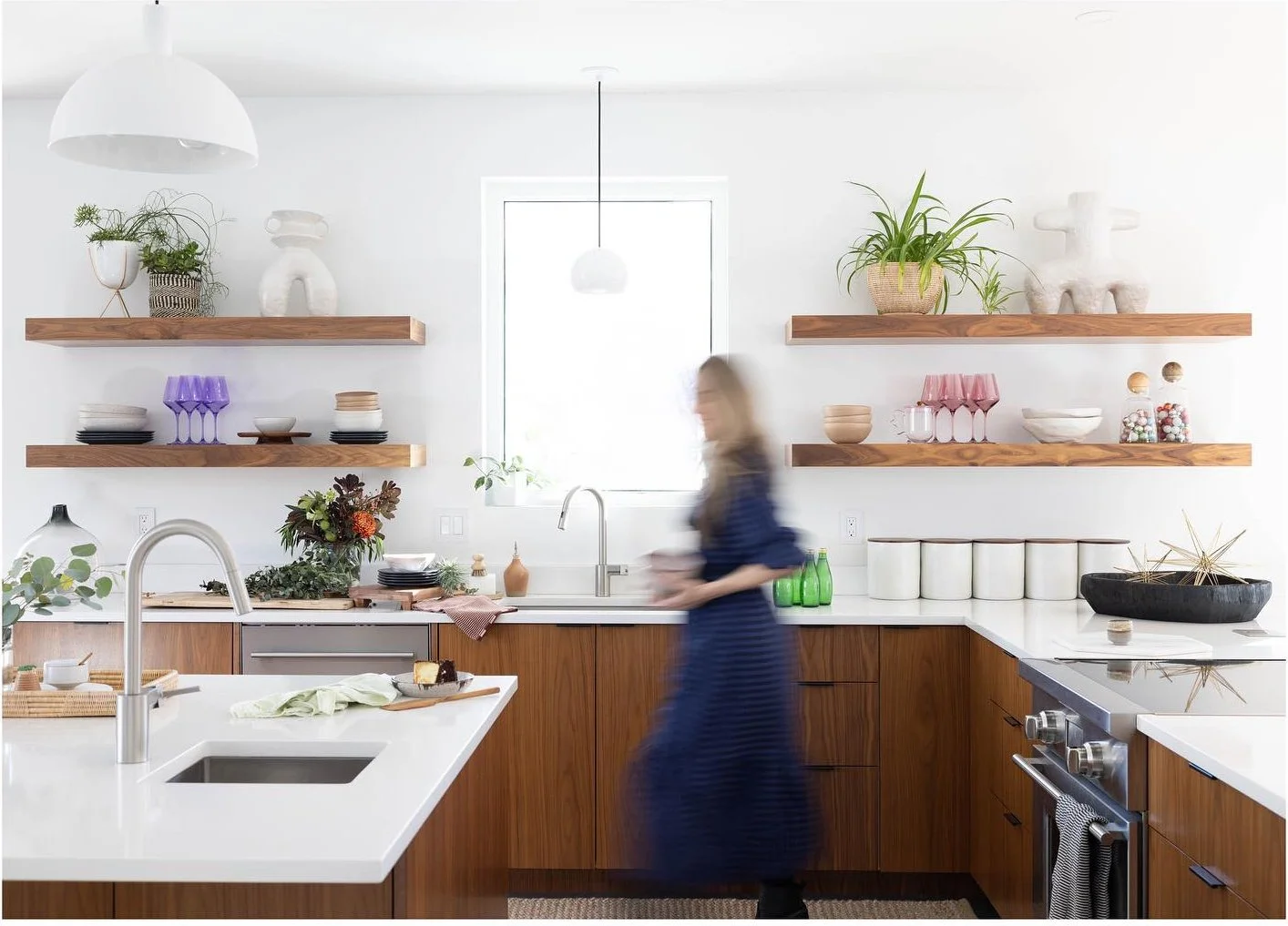 Styling team at work in a kitchen with wood cabinetry and pale counters
