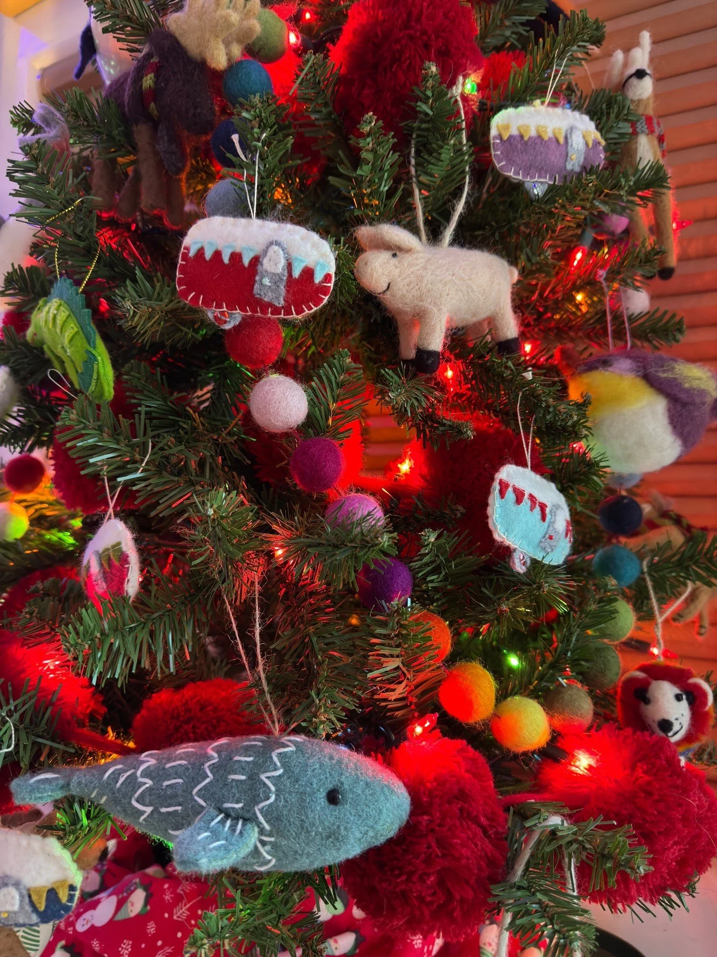 Multicolored ornaments and pom-poms on a Christmas tree
