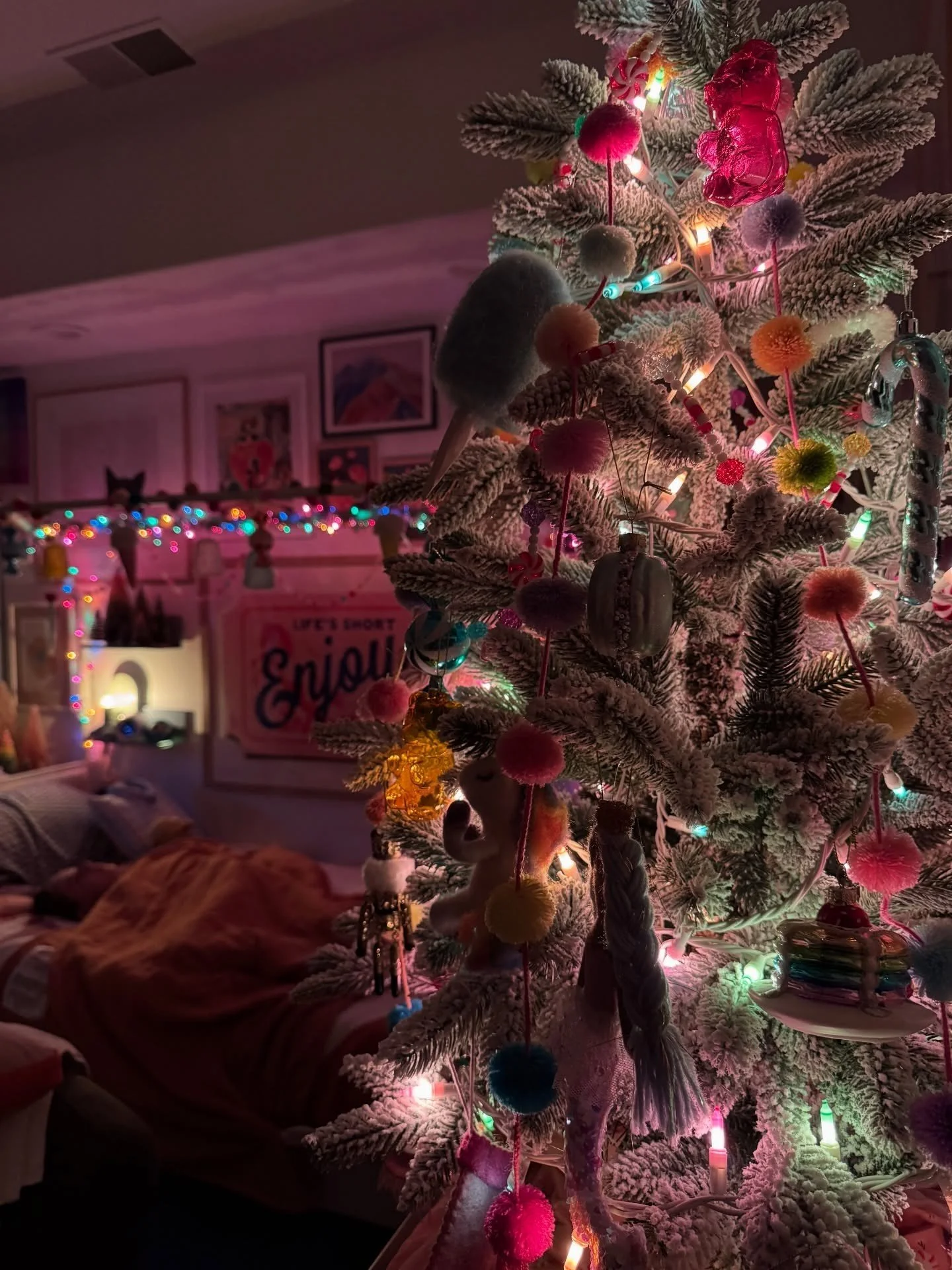 Layered bedroom with a Christmas tree and colorful lights
