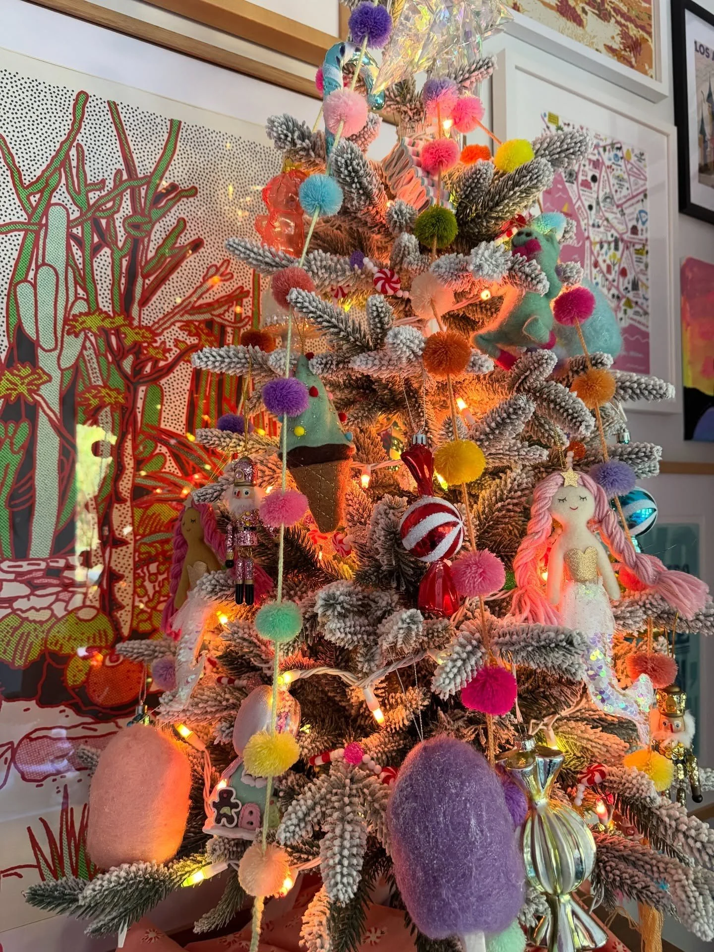 Christmas tree decorated with colorful ornaments beside a window