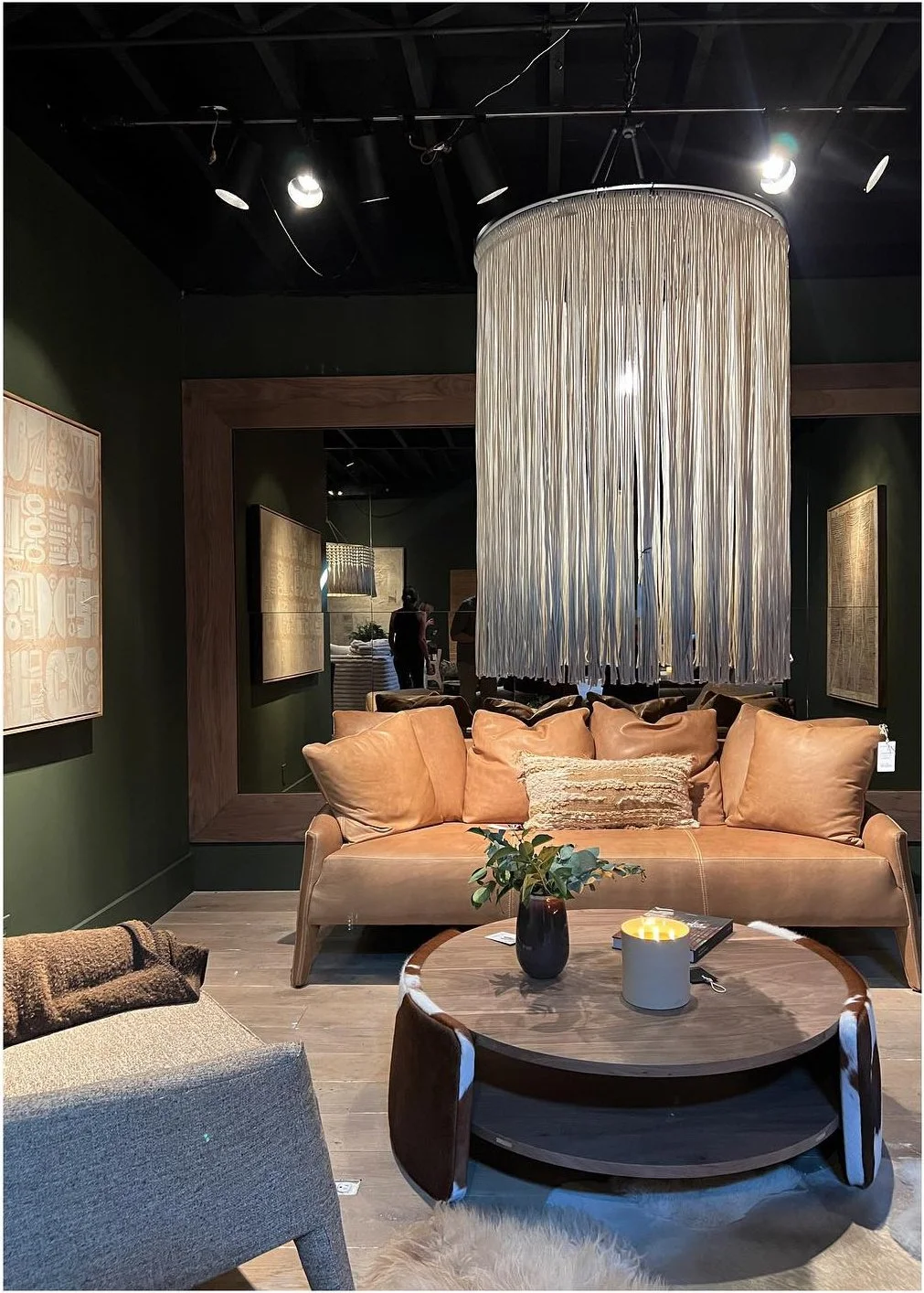 Pale curved sofa beneath a large cascading fringe chandelier