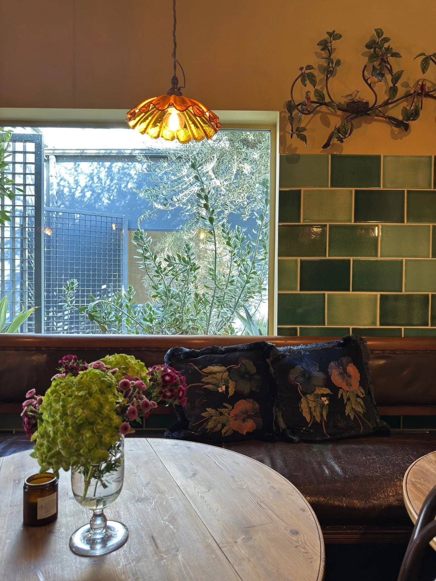 Cafe banquette with patterned upholstery and green tiled walls