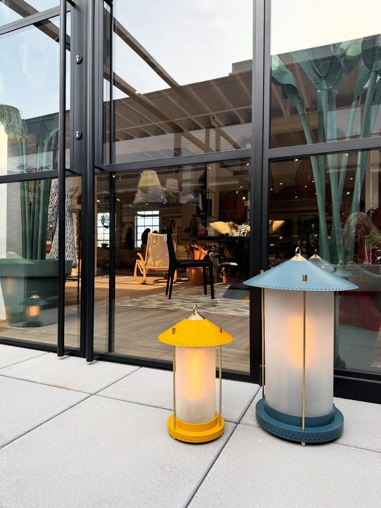 Small yellow and blue portable lamps beside tall glass doors
