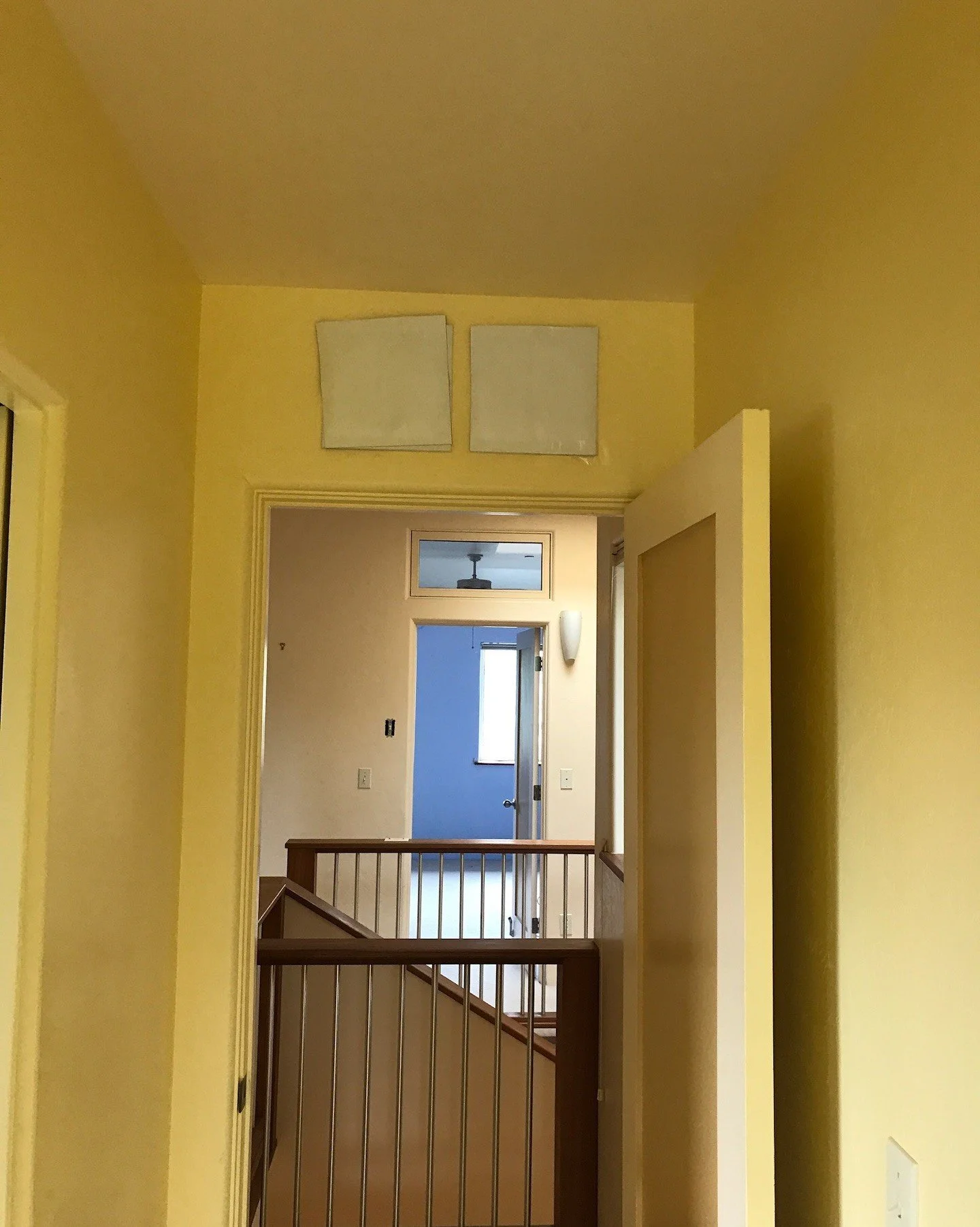 Yellow hallway with carpet and wood stair rails before work