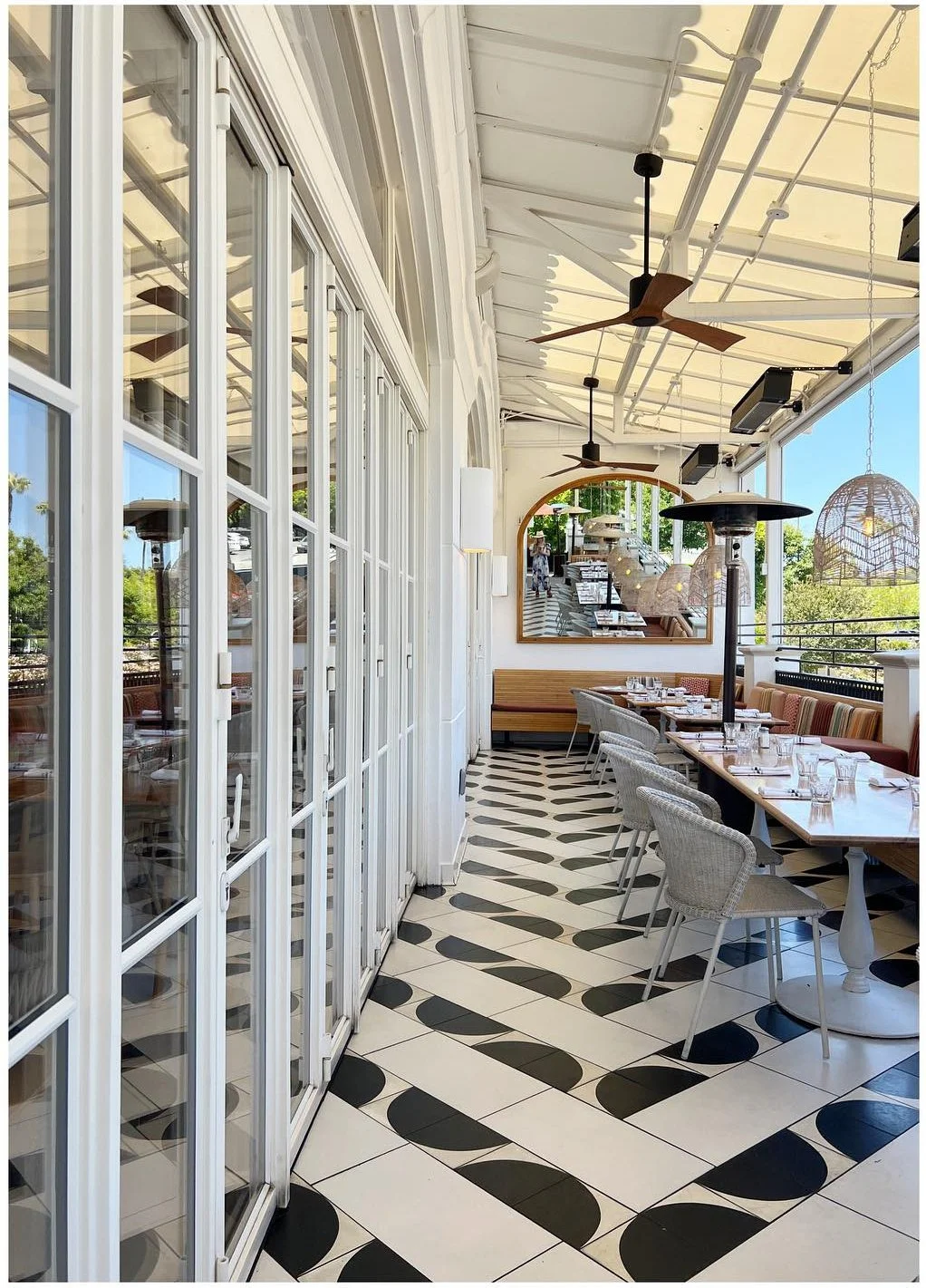 Bright café passage with black-and-white patterned floor tiles and tall glazed doors