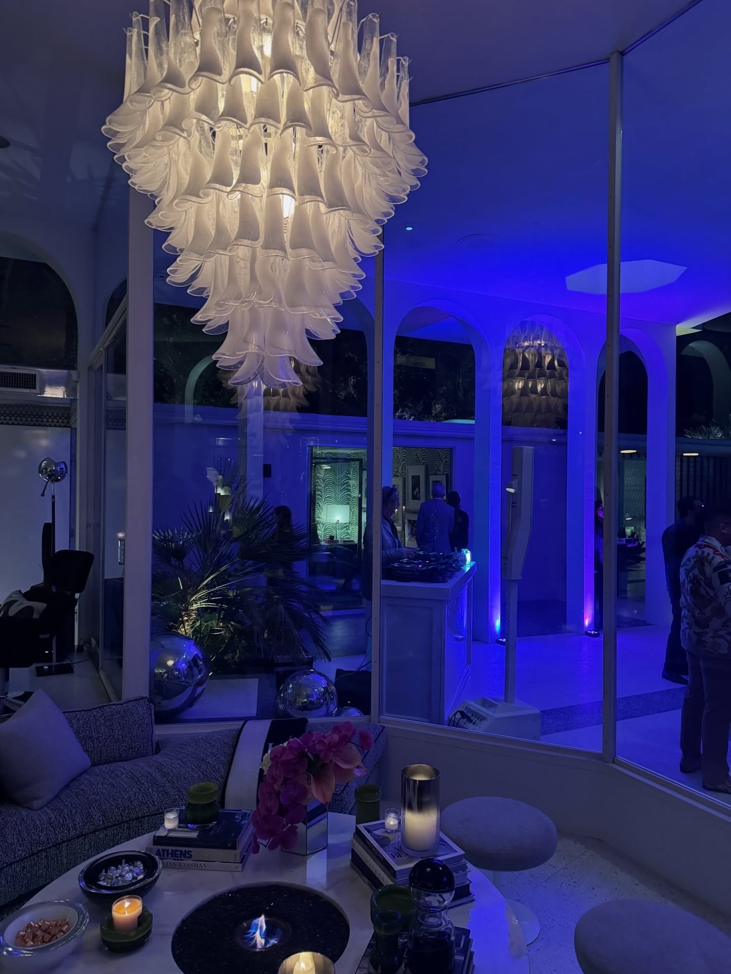 Living room with a large tiered chandelier and sculptural furniture