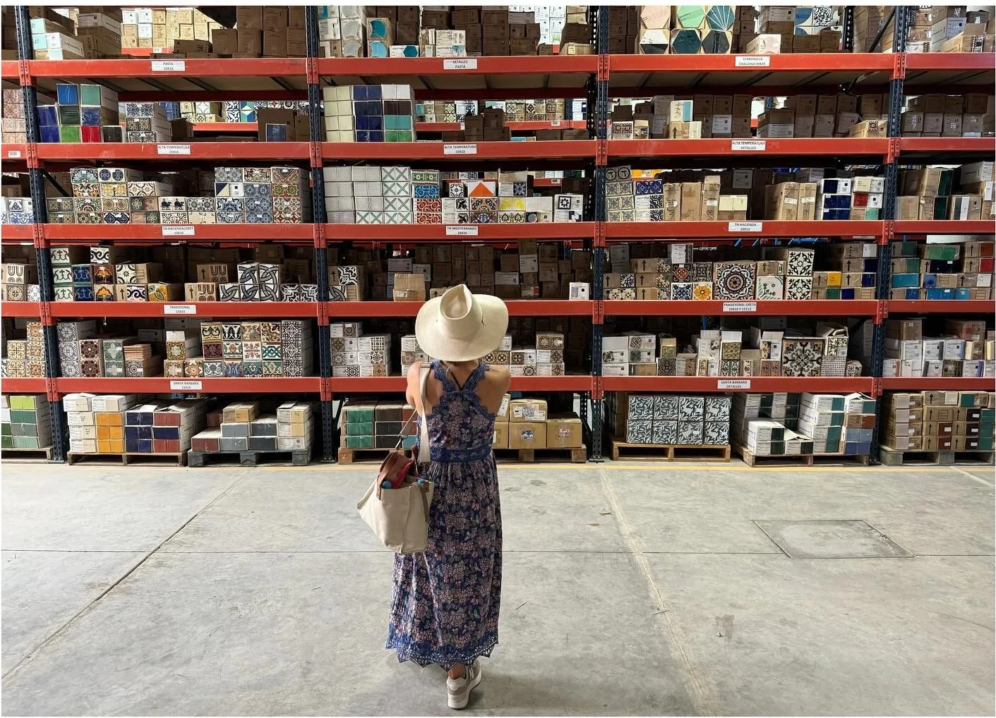 Amy reviewing shelves of material containers in a tile factory